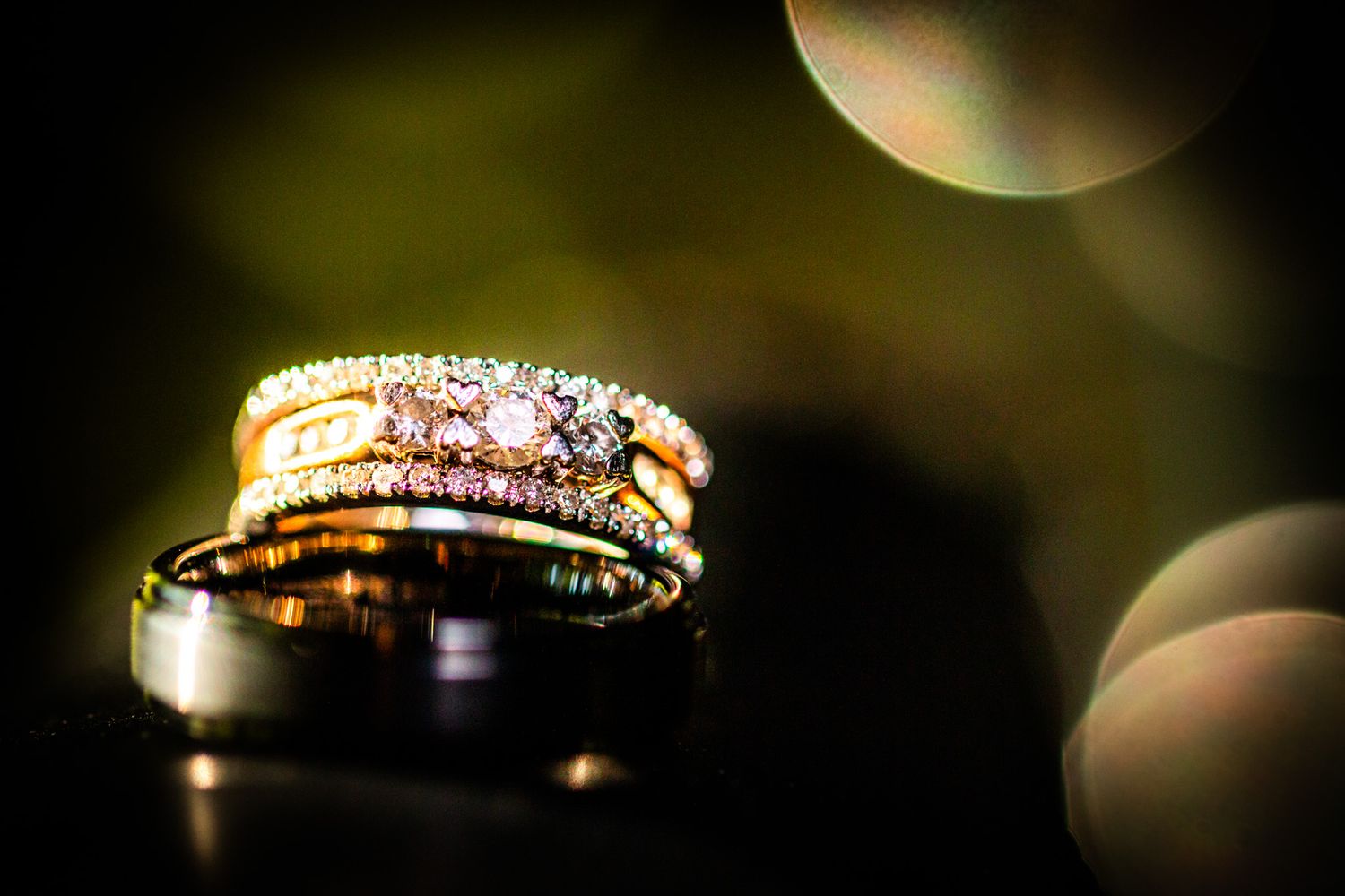 Wedding rings sparkle with bokeh light effects in an artistic macro photograph.