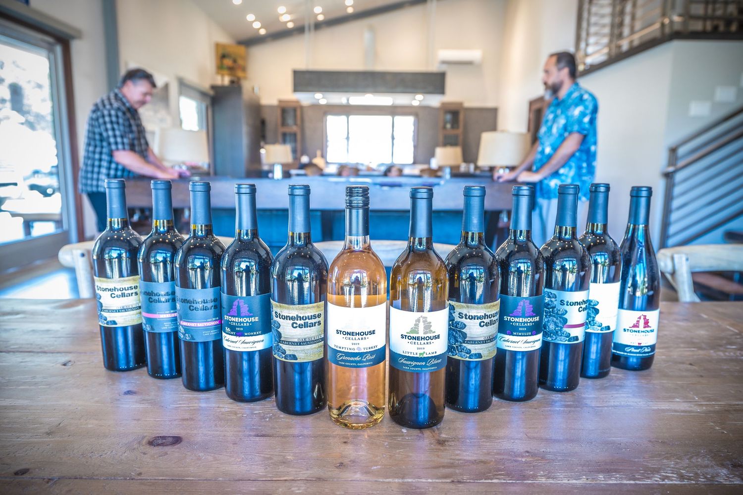 Collection of wine bottles arranged in a curved display on a modern tasting room counter.
