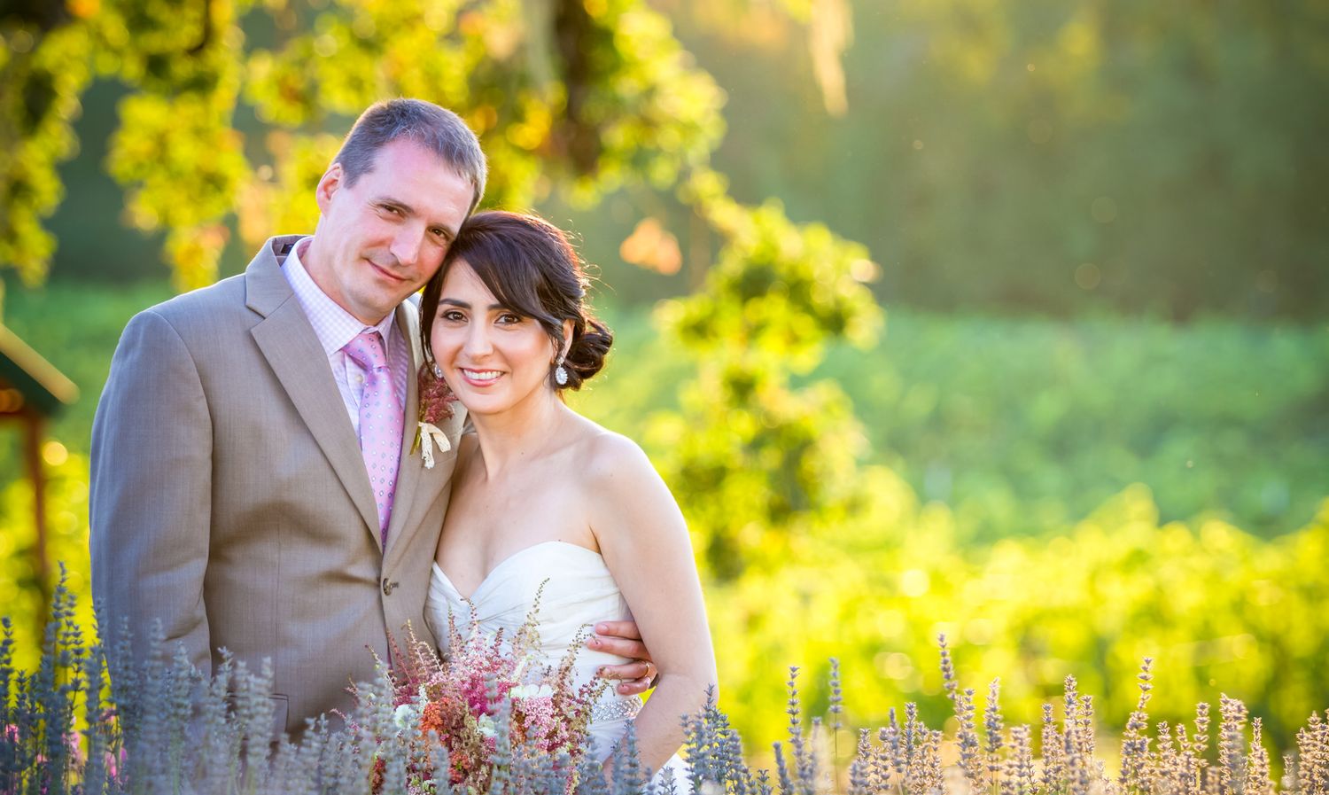 Romantic wedding portrait in field of wildflowers during golden hour.