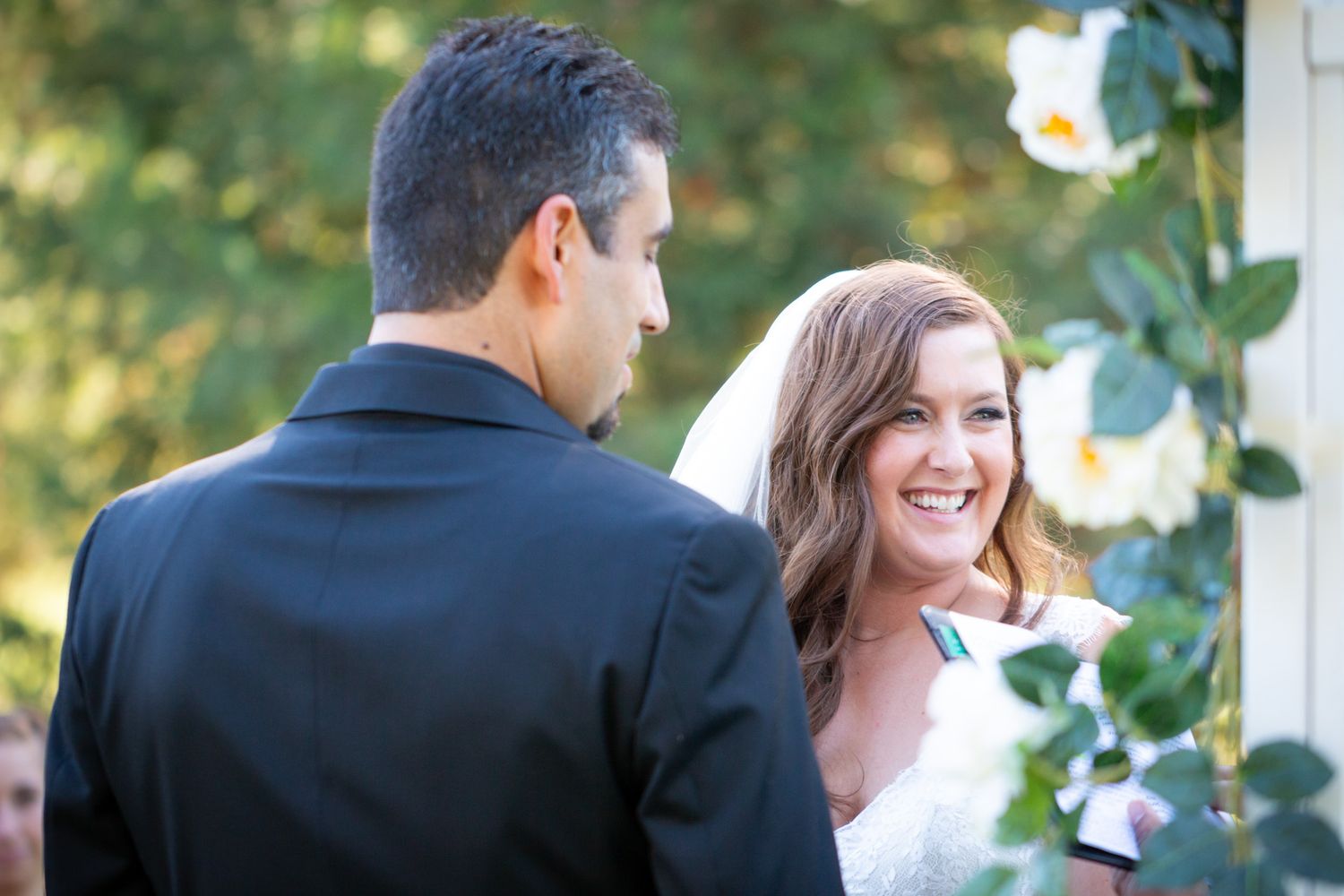 Couple shares joyful moment during outdoor garden wedding ceremony.