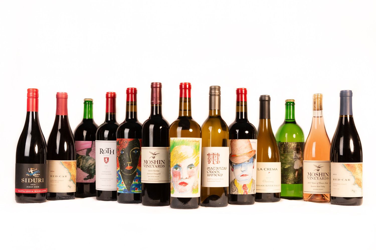 Collection of various wine bottles arranged in a row on white background.