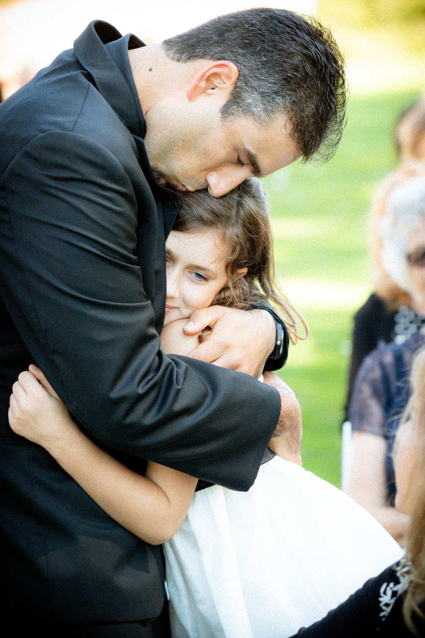 An emotional embrace during an outdoor wedding ceremony.