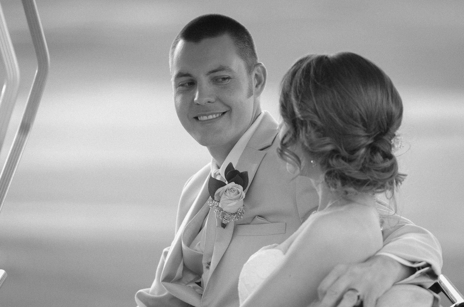 Black and white candid wedding photo showing couple sharing a tender moment.