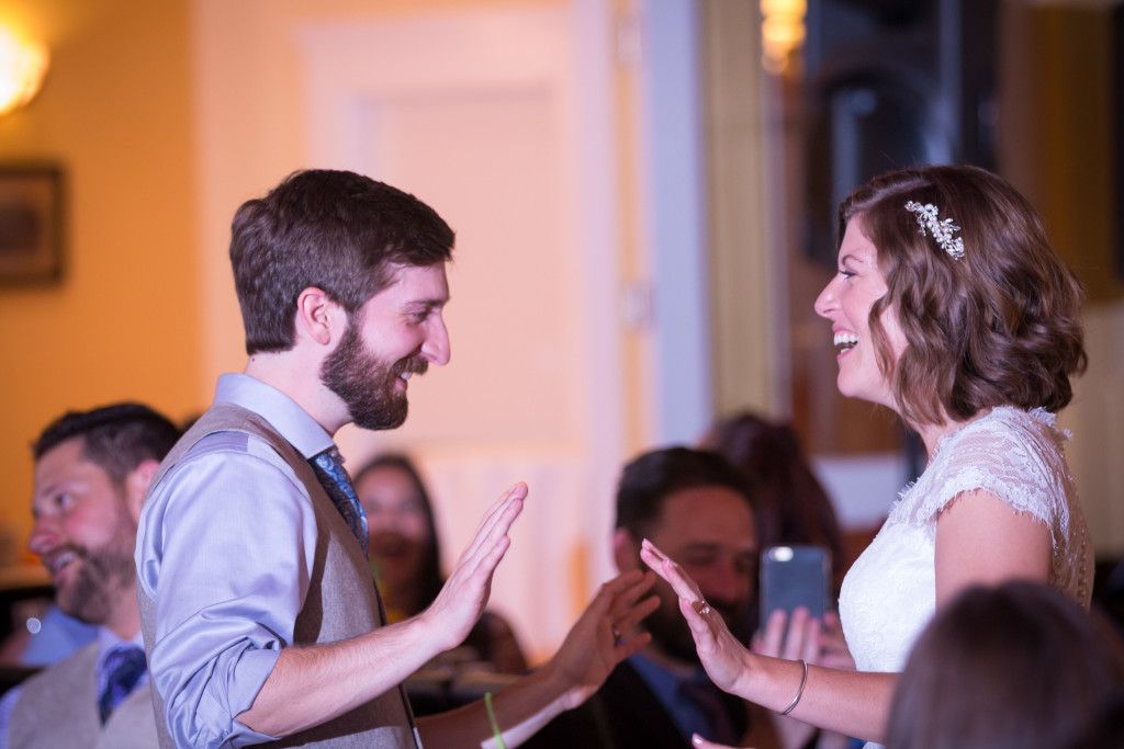 Couple sharing a lively moment during wedding reception festivities.