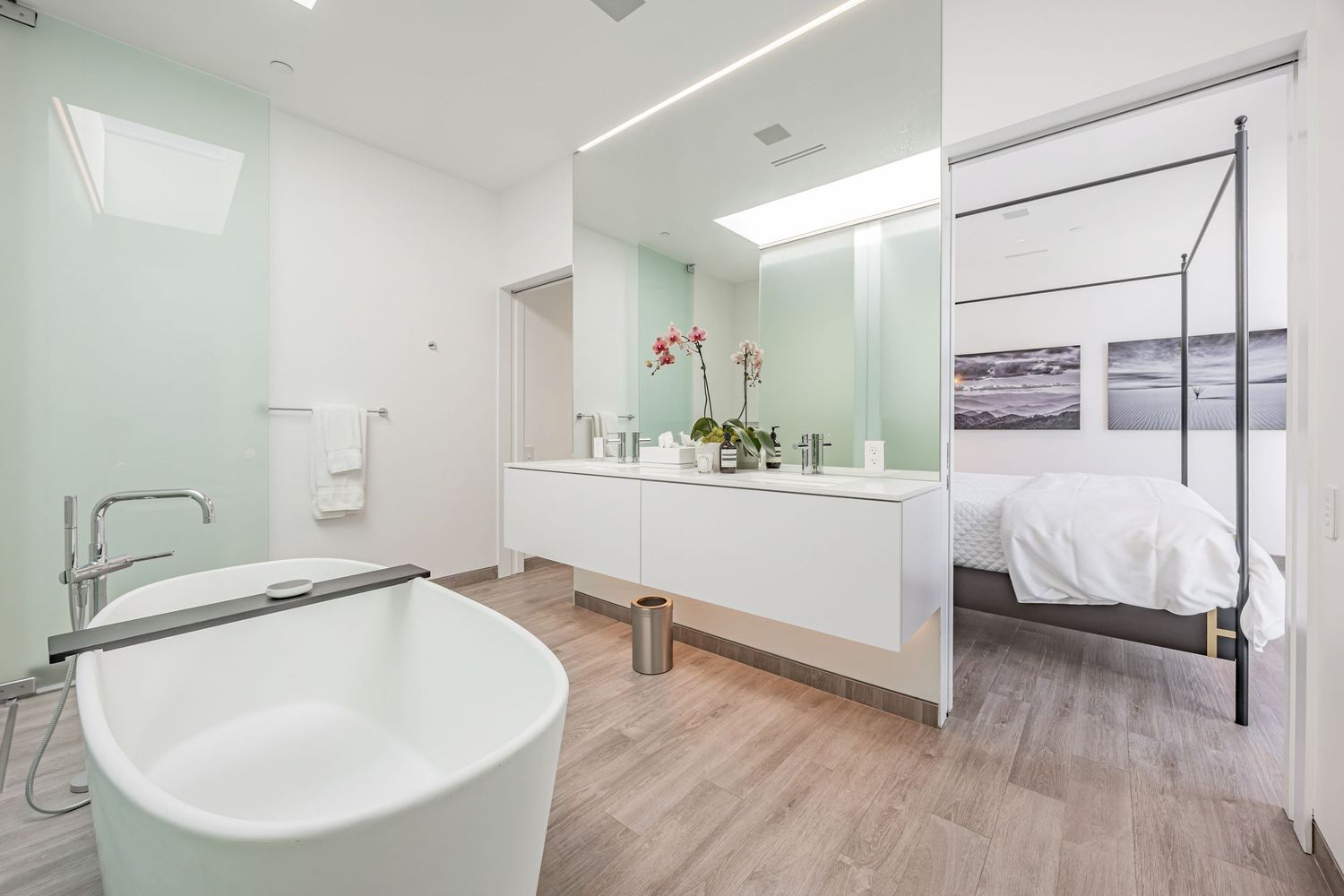 Bright modern bathroom with freestanding tub and white vanity.