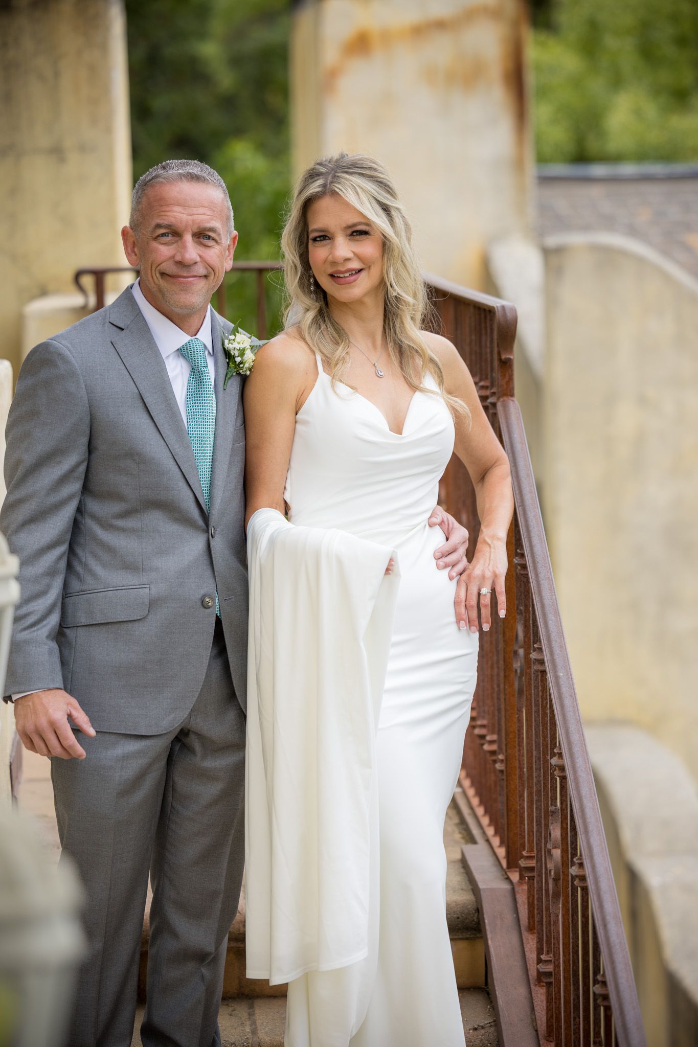Wedding couple posing together on rustic staircase.