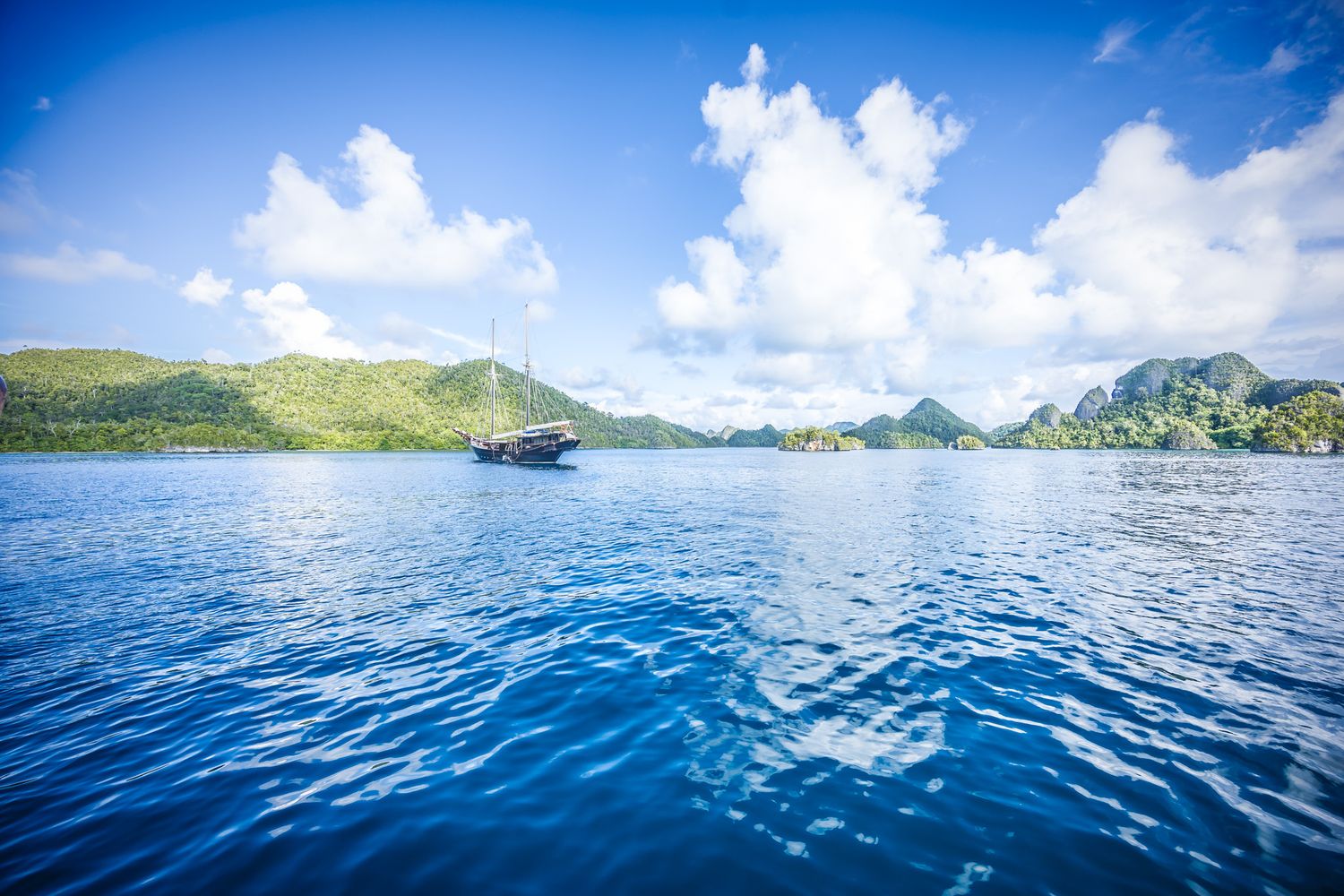 Tropical island lagoon with turquoise waters surrounded by lush green mountains.