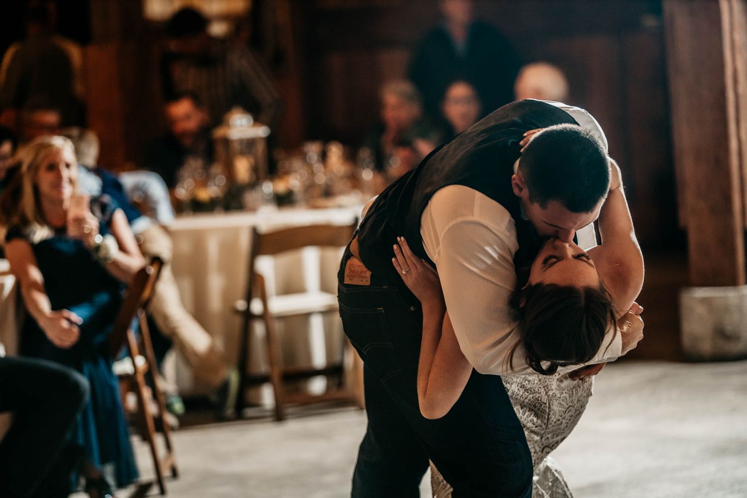 A romantic dip on the dance floor at a rustic wedding reception.