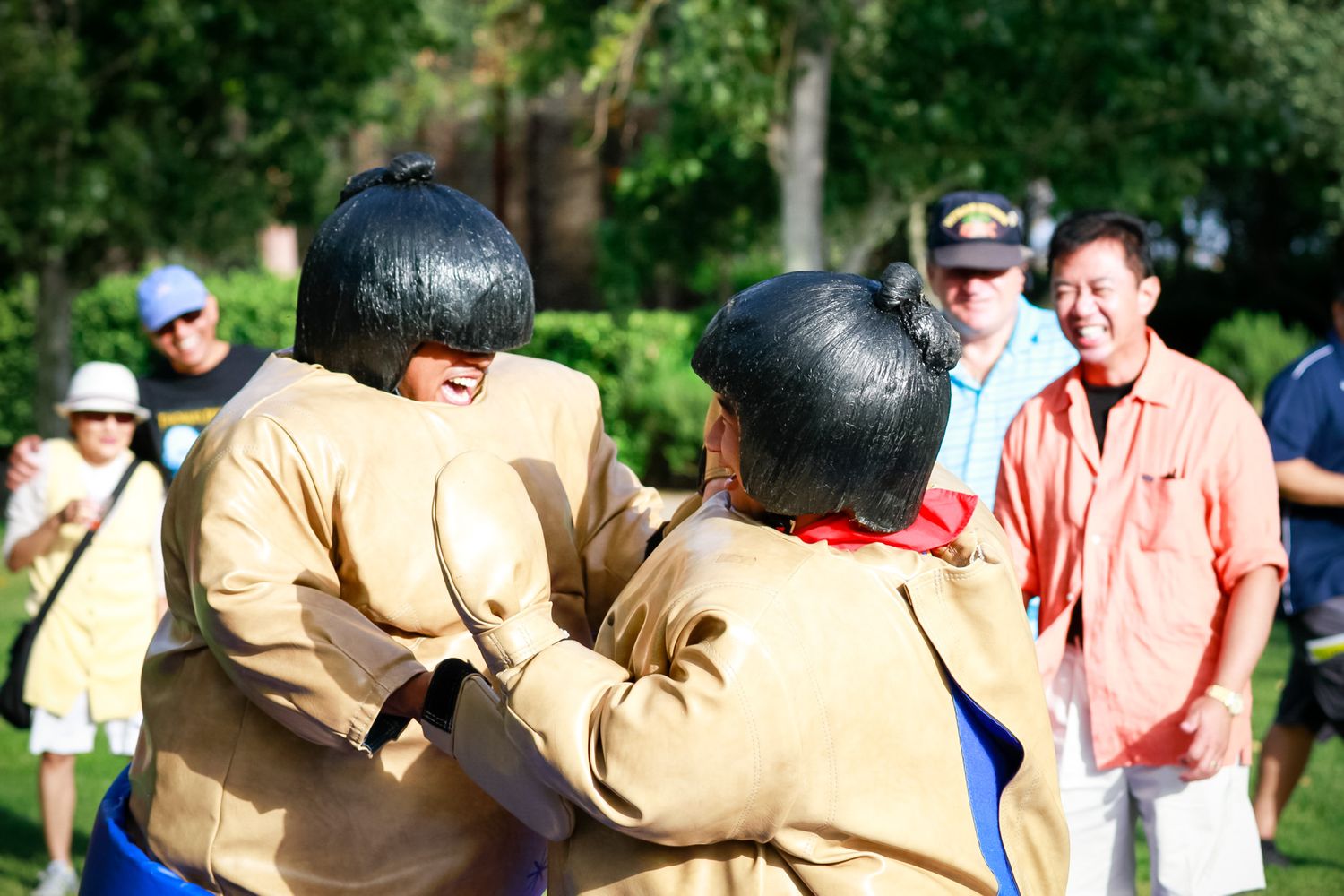 Participants in sumo costumes engaged in outdoor recreational activity.