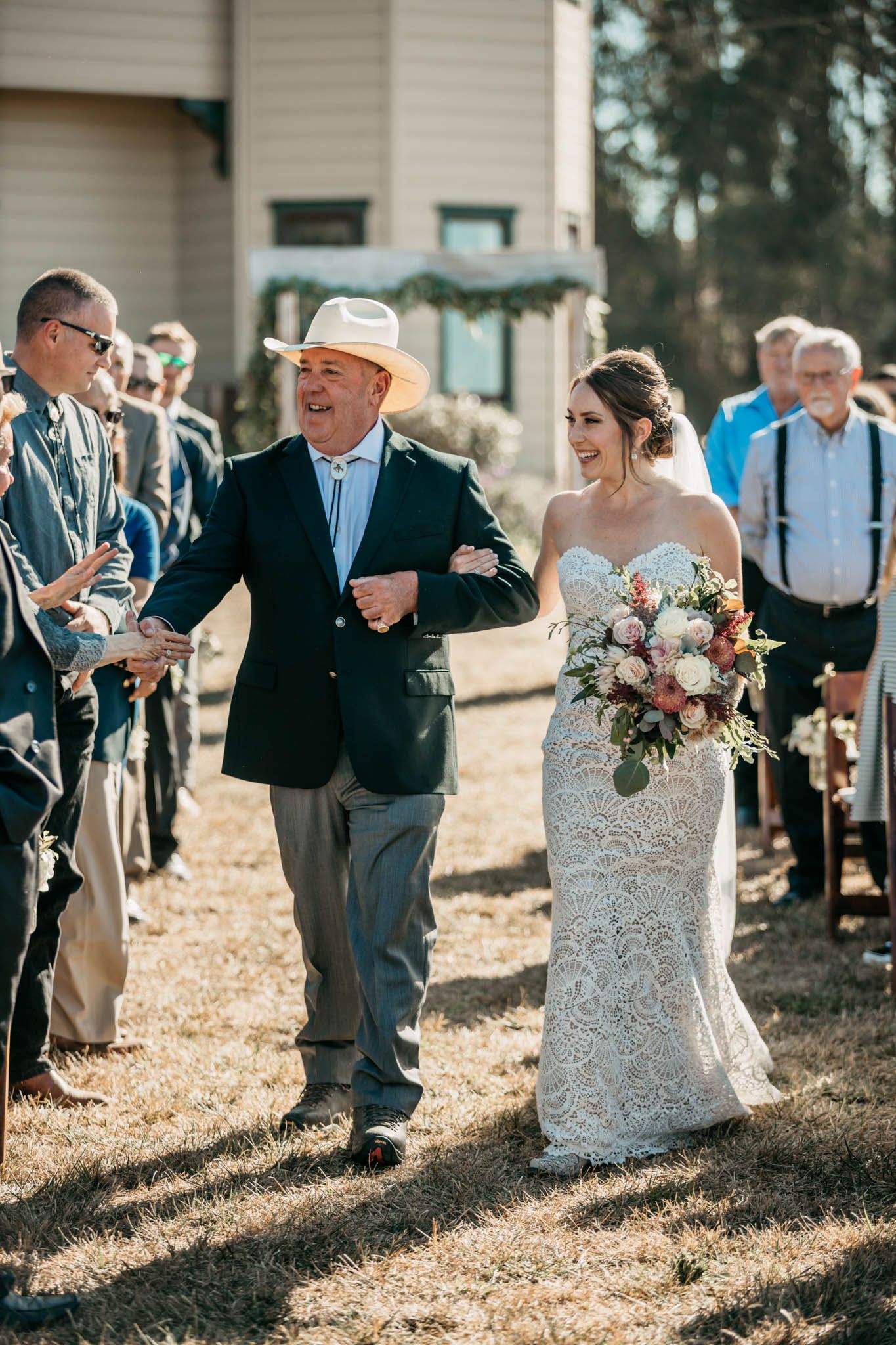 Wedding party walking down outdoor path during autumn ceremony.
