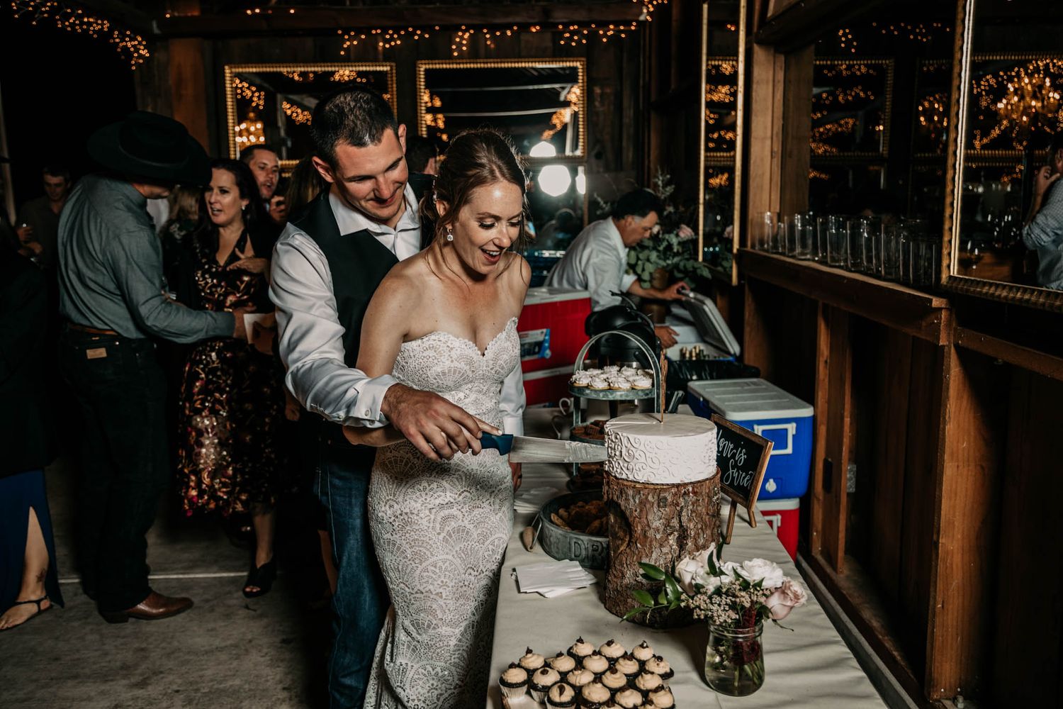 Newlyweds cutting their rustic wedding cake together at reception.