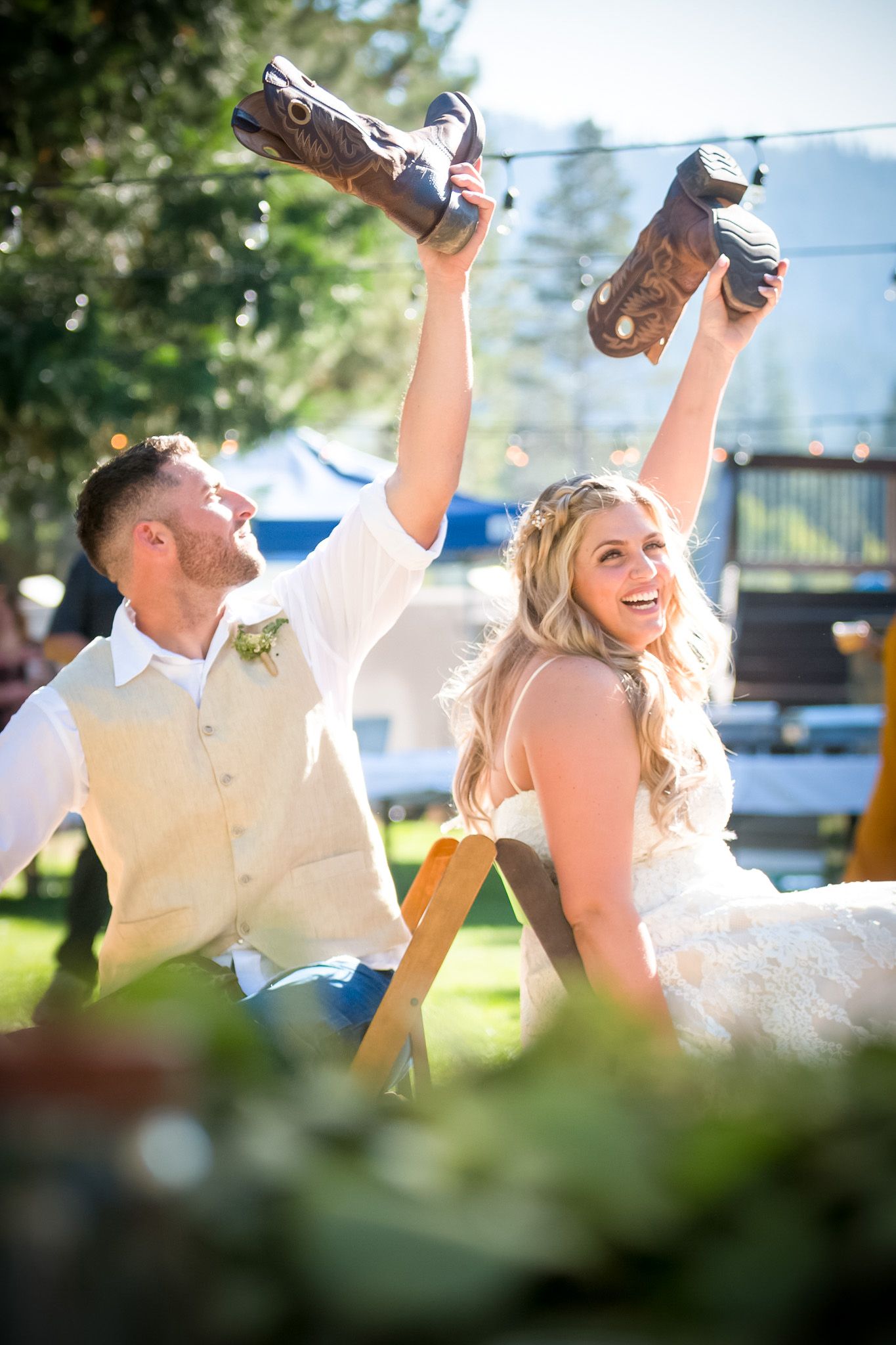 Newlyweds celebrate by raising drinks during outdoor reception.