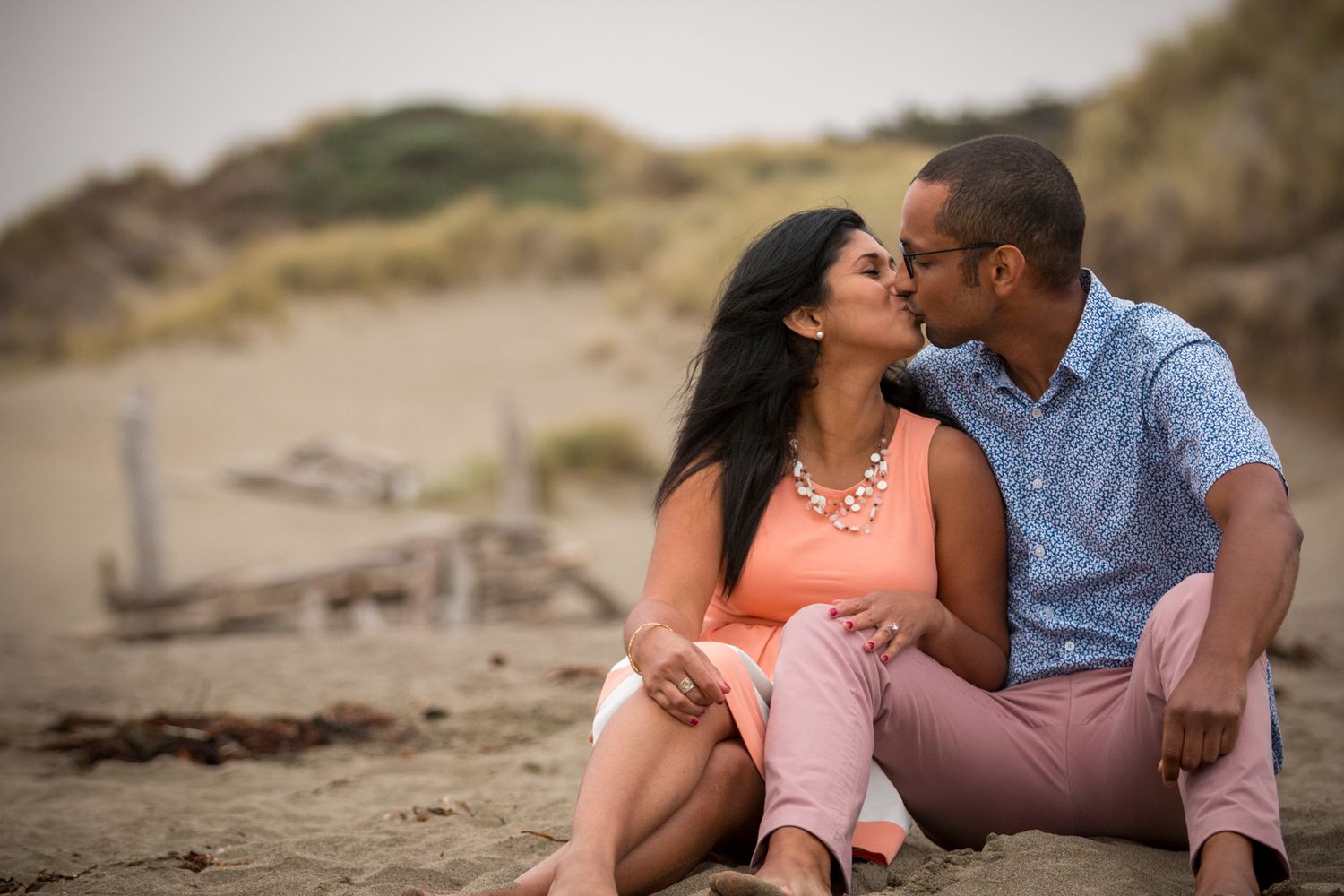 A couple sharing an intimate moment while sitting on a beach.