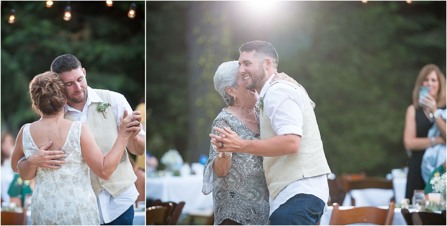 People dancing together at an outdoor summer wedding reception with string lights and greenery in the background.