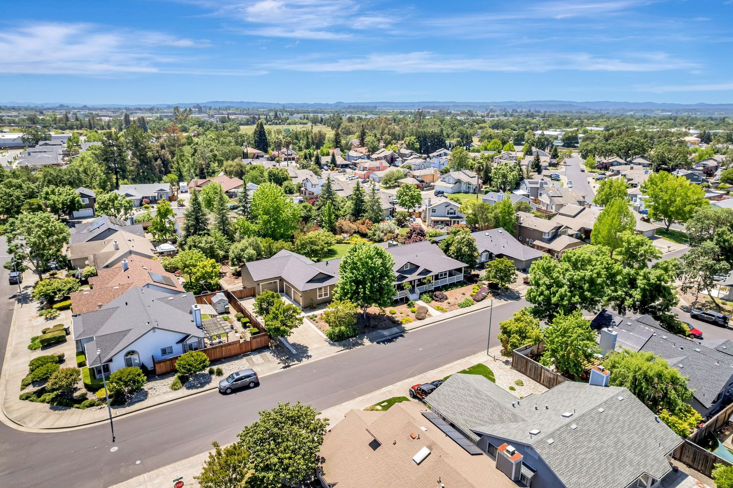 Overhead view of suburban neighborhood showing winding roads and well-maintained properties.