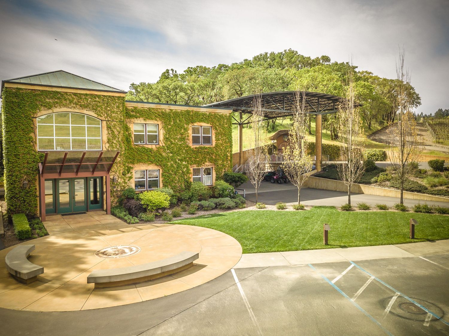 Ivy-covered winery building with modern architectural features and outdoor amphitheater.