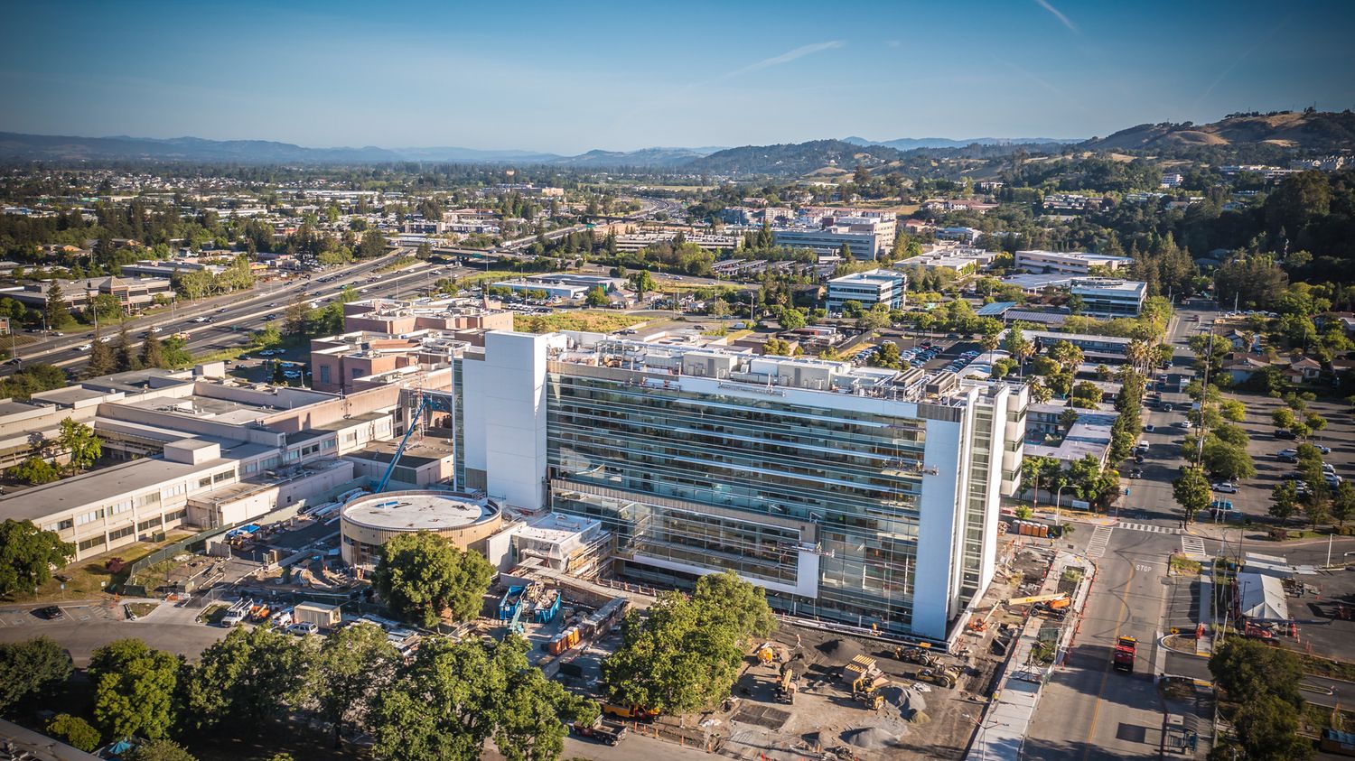 Modern office building complex viewed from above with surrounding parking and infrastructure.