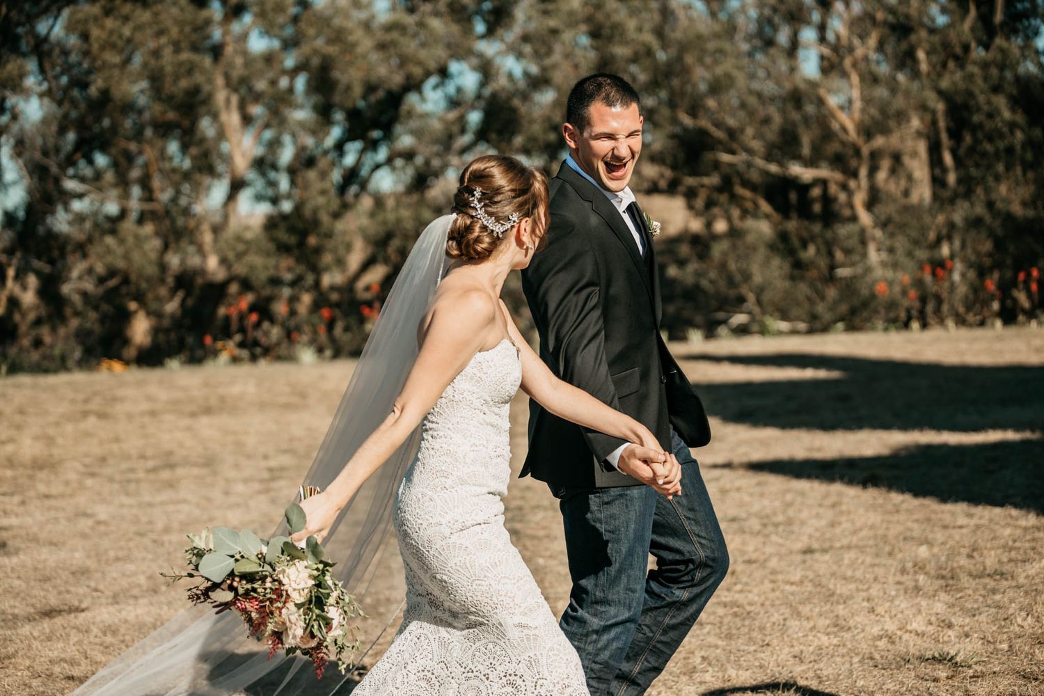 Couple walking together outdoors during rustic countryside wedding.