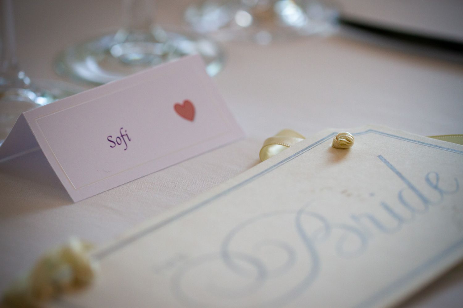 Close-up shots of elegant wedding stationery with delicate handwriting and heart details.