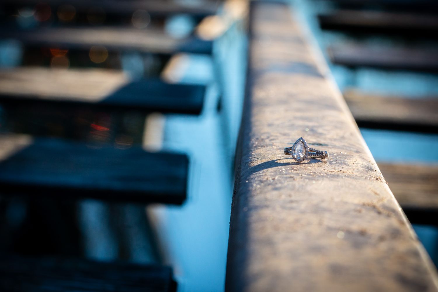 Close up macro shot of a worn wooden stadium bench seat with a small maple leaf logo engraved on the surface.