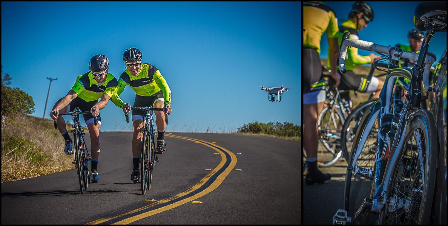 Cyclists in bright yellow jerseys ride together on winding road with drone perspective.