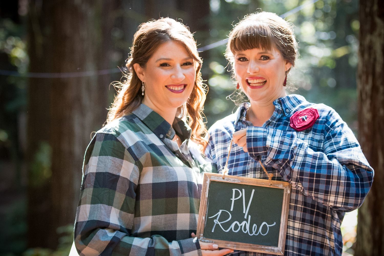 Friends displaying chalkboard messages while wearing coordinated plaid outfits.