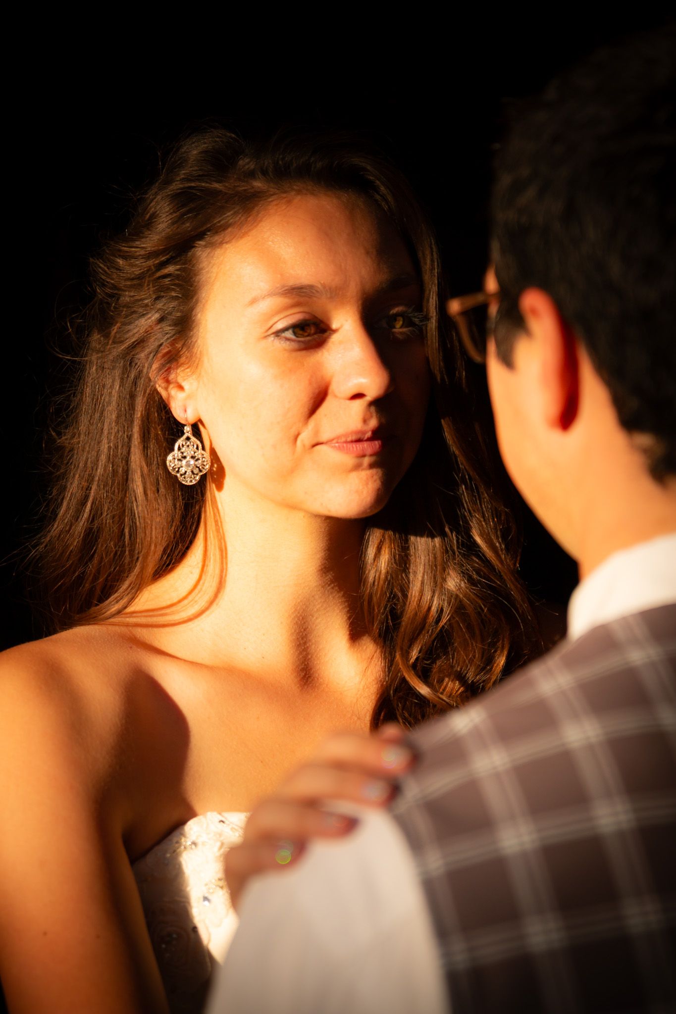 Golden hour portrait of couple illuminated by warm sunset light.
