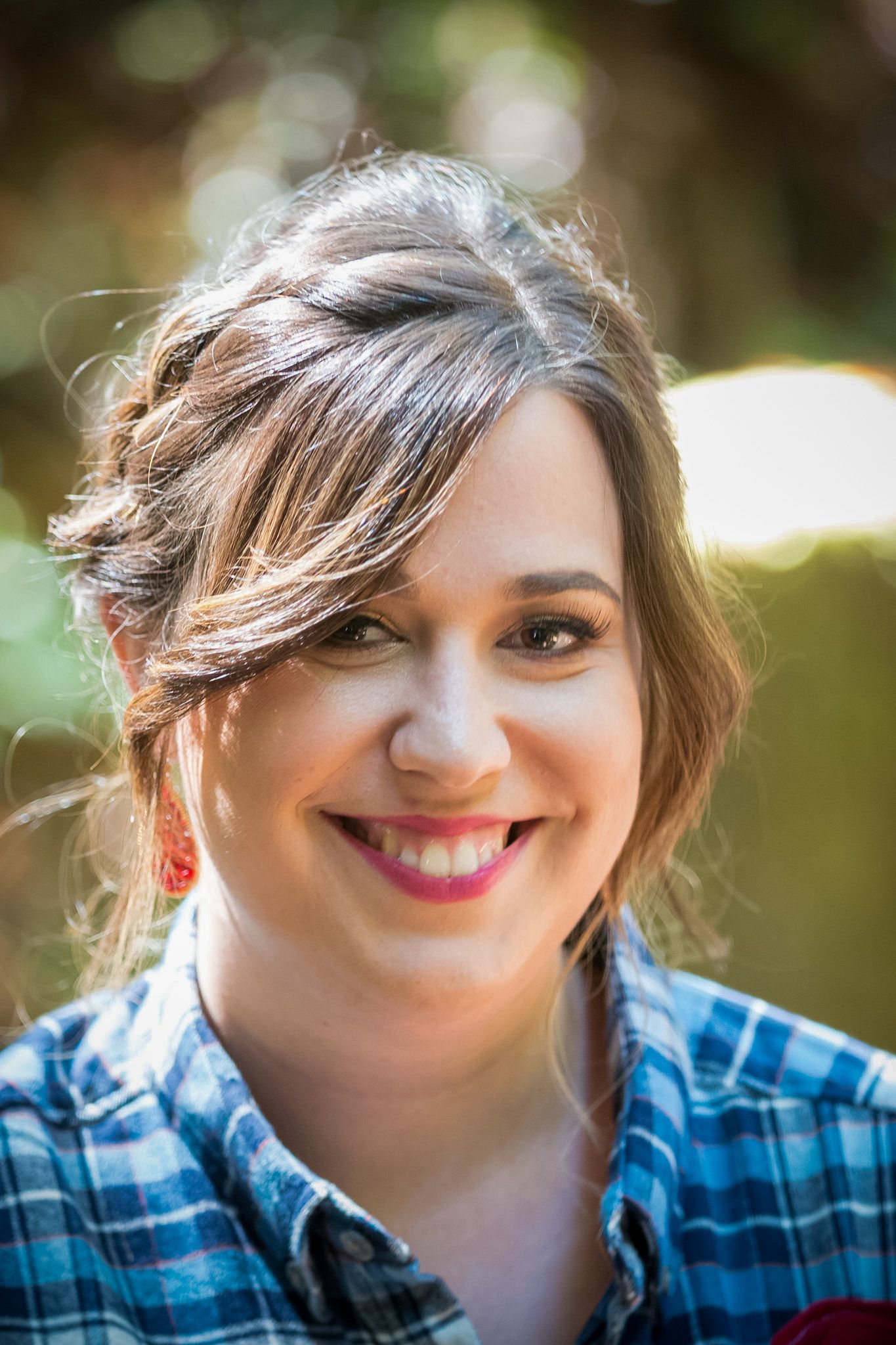 Casual outdoor portrait featuring plaid shirt and natural lighting.