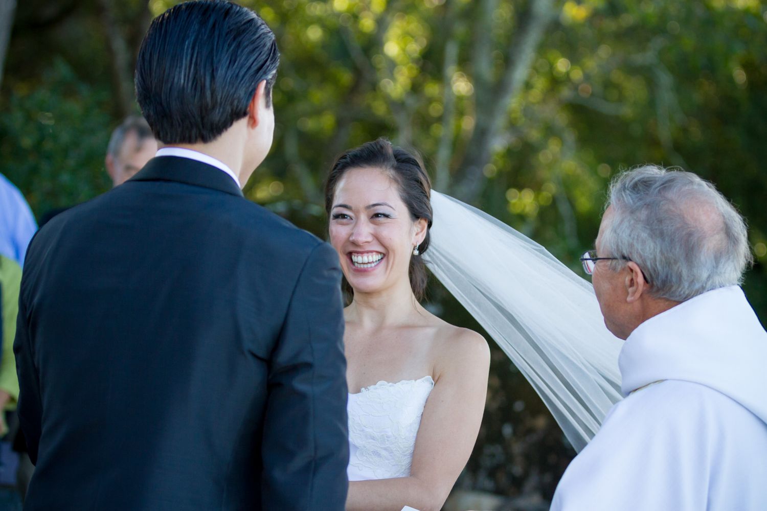 Couple exchanges vows during outdoor wedding ceremony with officiant.