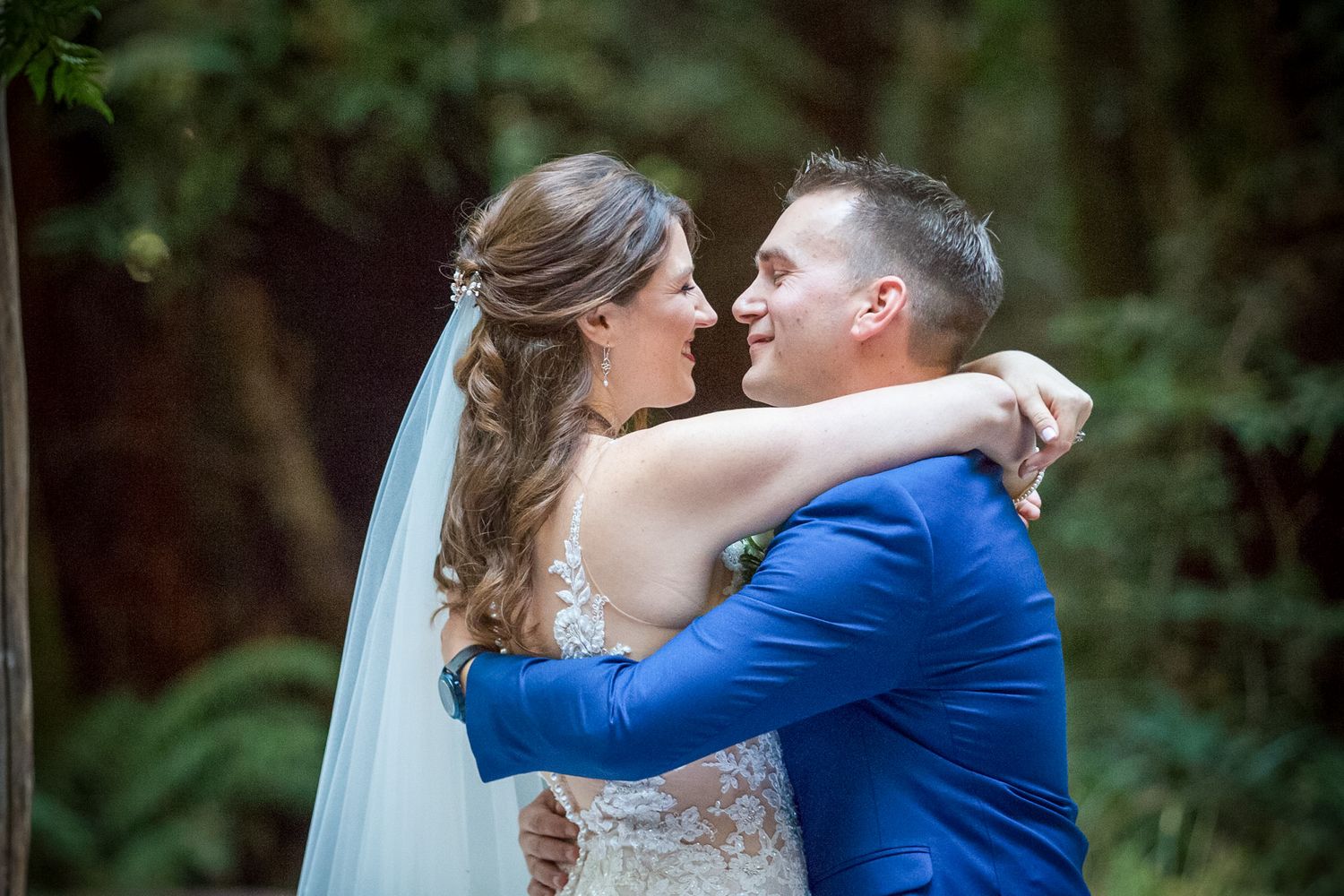 A romantic first dance moment between newlyweds under an outdoor wedding canopy.