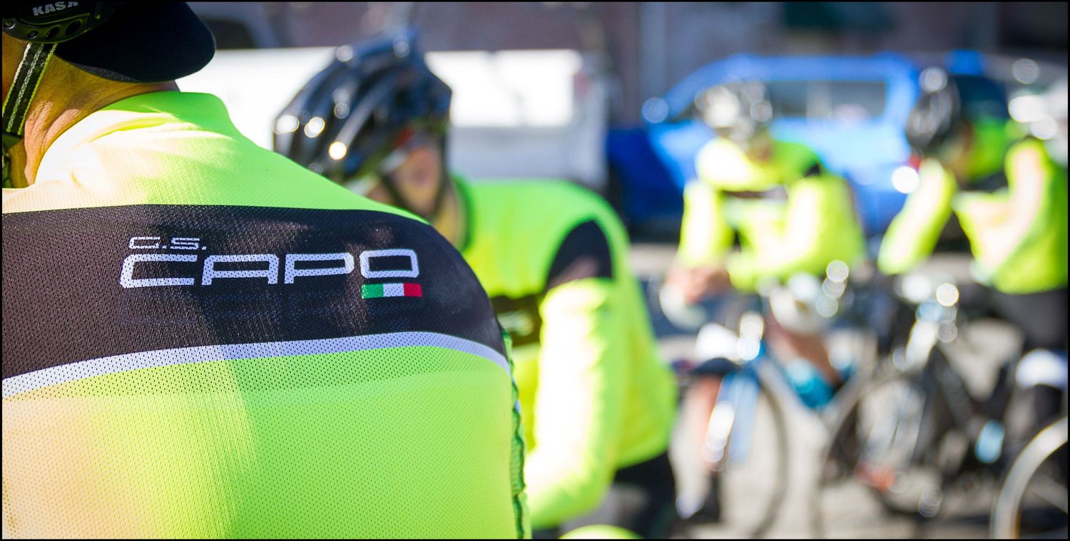 Close-up detail of CAPO cycling team jersey in bright yellow and carbon gray colors.