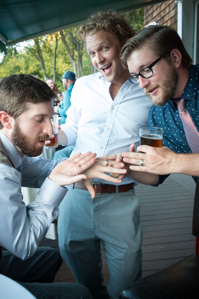 Group examining rings during outdoor wedding celebration.