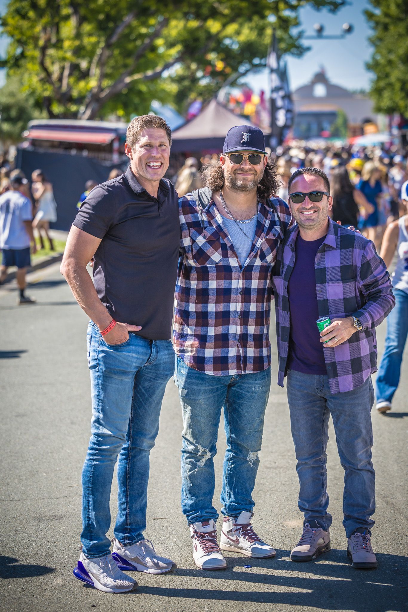 A series of lower body shots showing people in jeans and casual shoes standing together at an outdoor event.