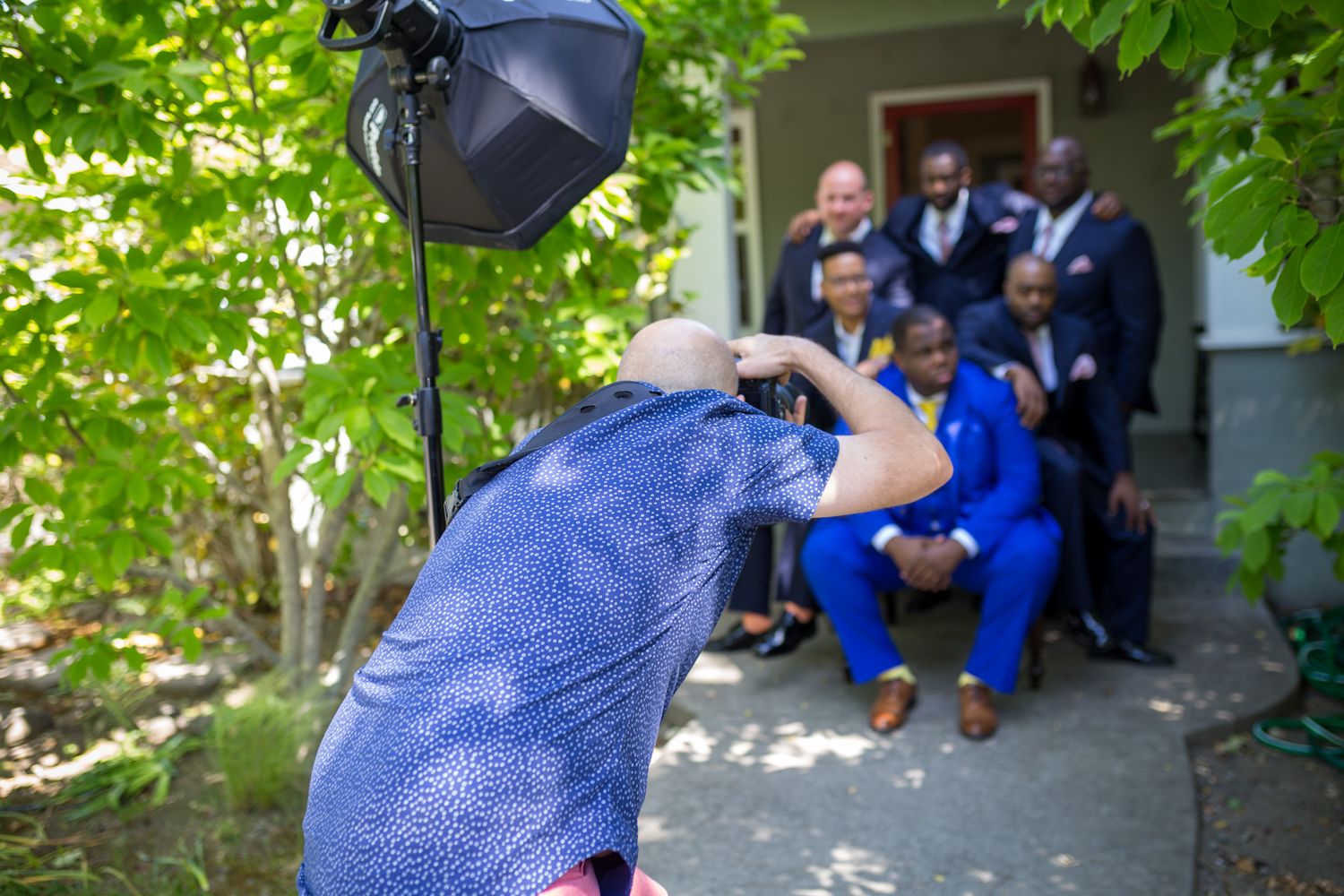 Behind the scenes photo of a photographer shooting with lighting equipment outdoors.