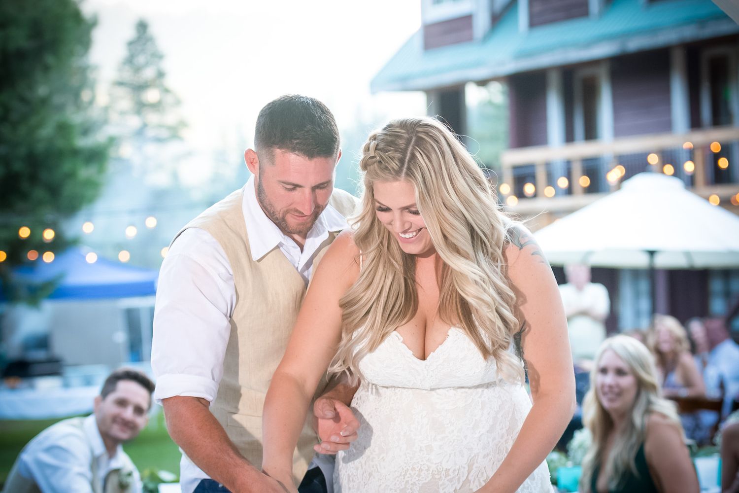 A couple shares an intimate moment during their outdoor reception under string lights.