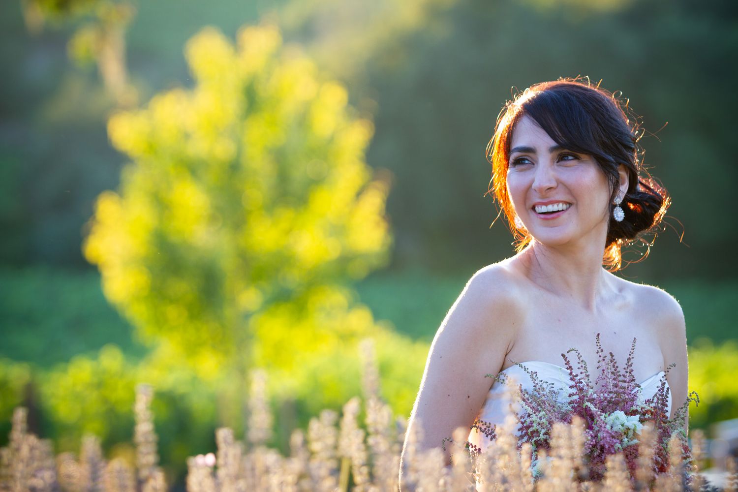 Elegant bridal portrait in a sunlit field of lavender during golden hour.
