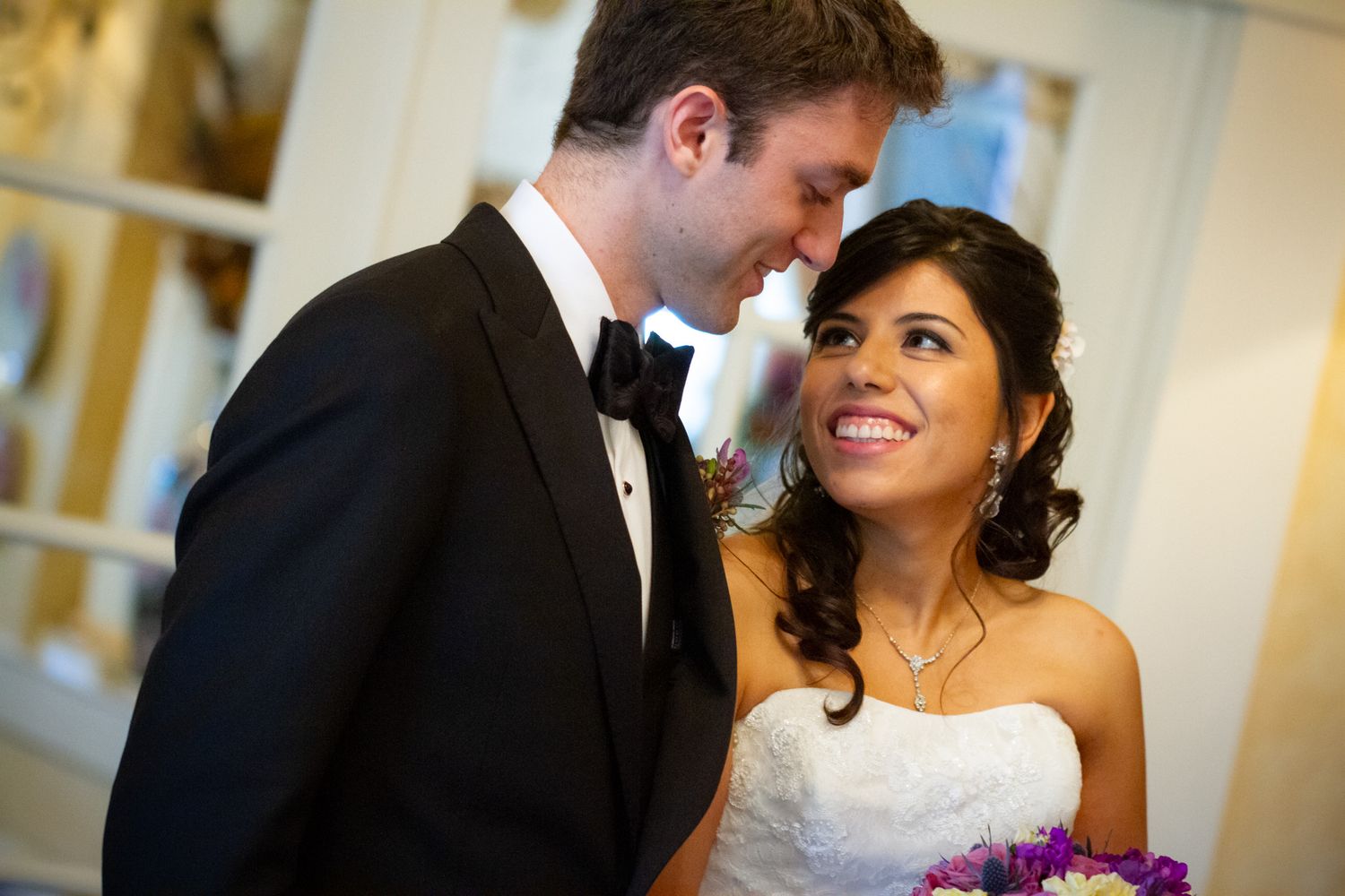 A couple shares an intimate moment at their formal wedding.
