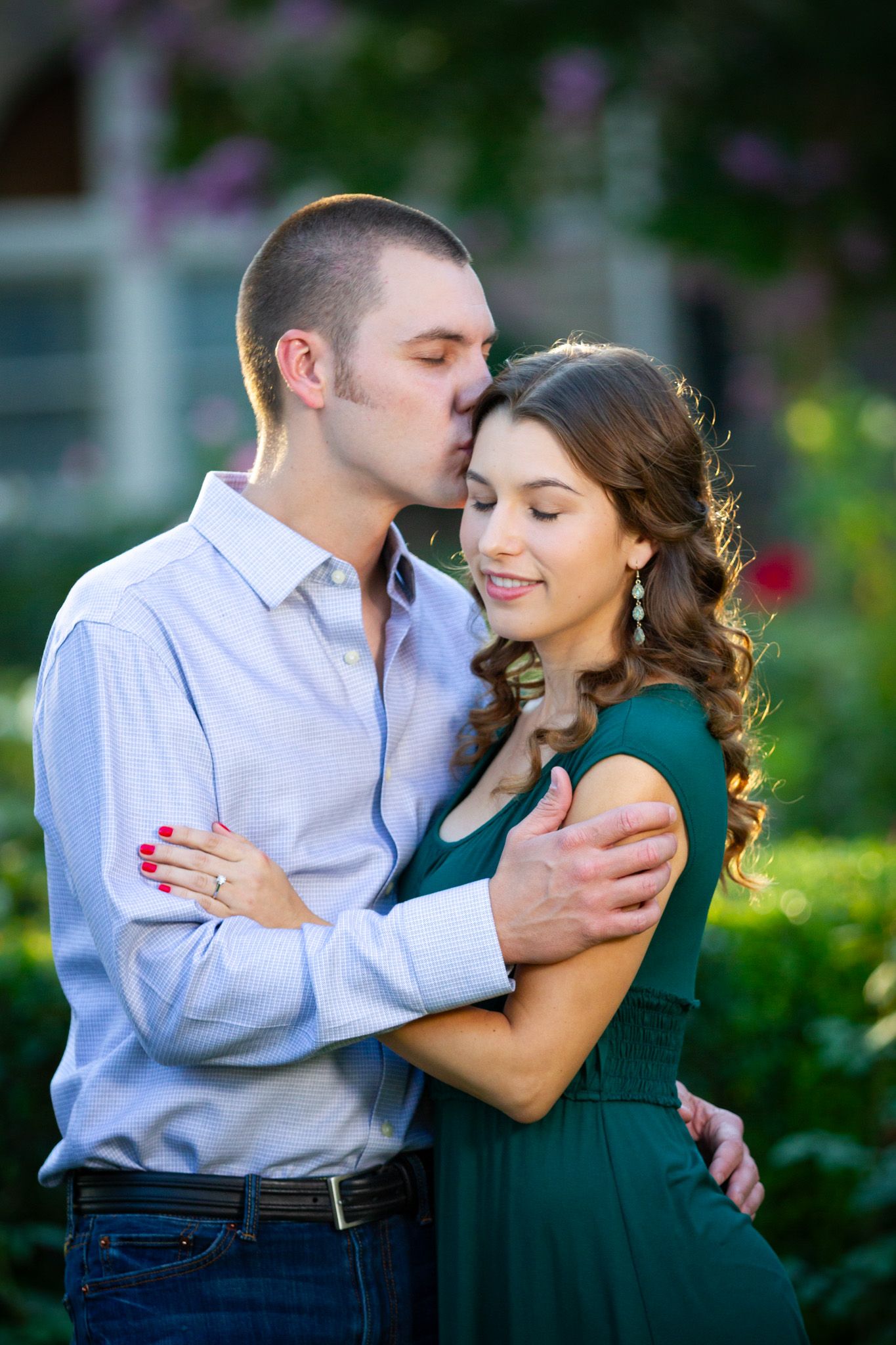 Romantic outdoor portrait of couple embracing in a garden setting.