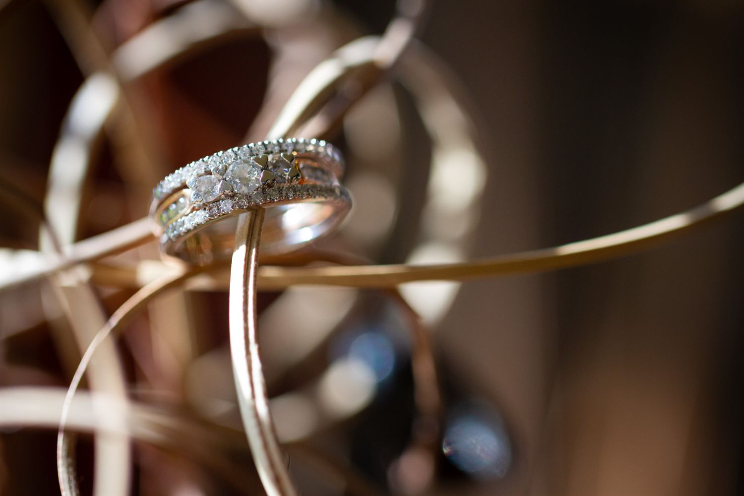 Macro shot of diamond wedding ring with decorative ribbon background.