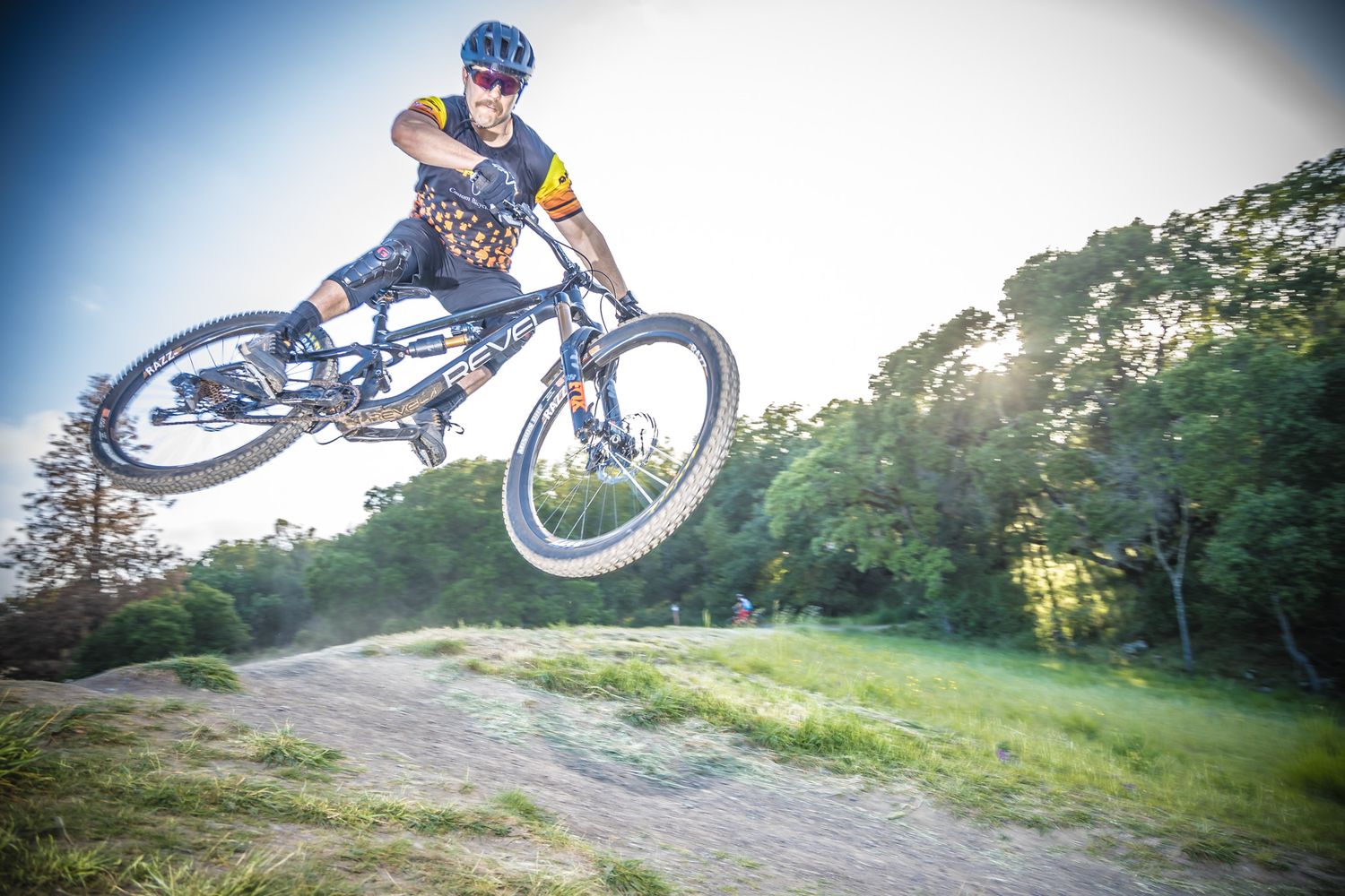 Action shots of a mountain biker doing aerial tricks and jumps on a trail.
