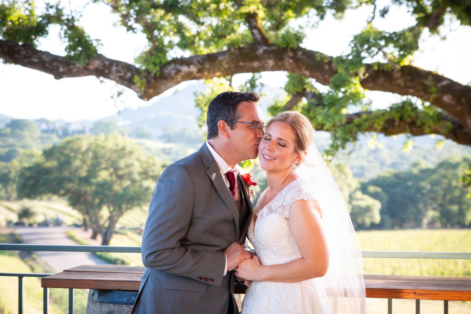 Evening wedding portrait on path with glowing lights in background.