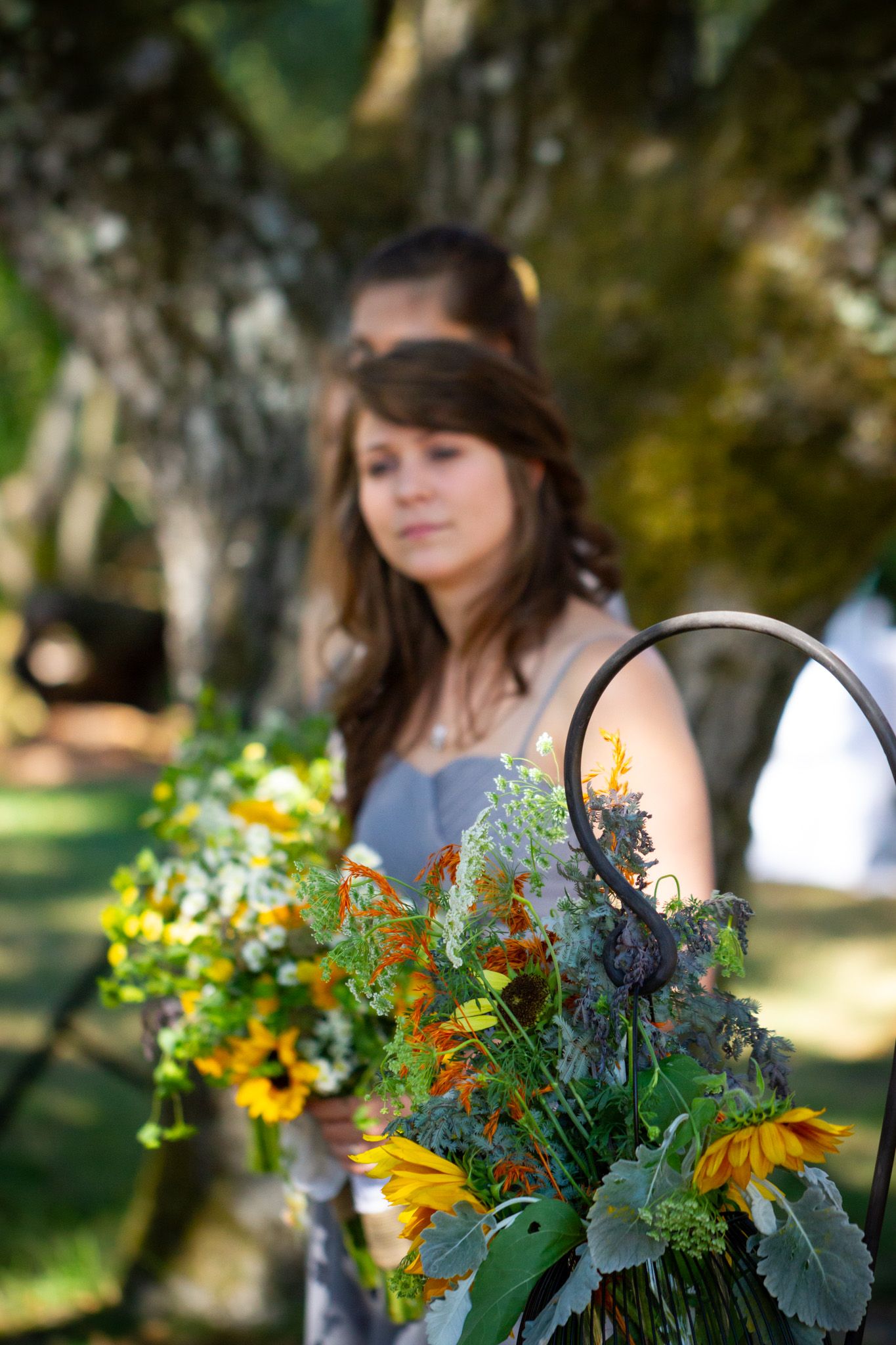 A colorful bouquet with sunflowers and wildflowers in a garden setting with natural bokeh background.