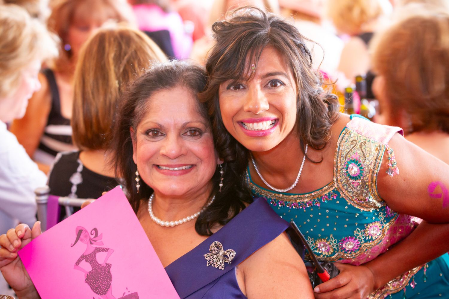 Party celebration with women in formal attire and colorful decorations.