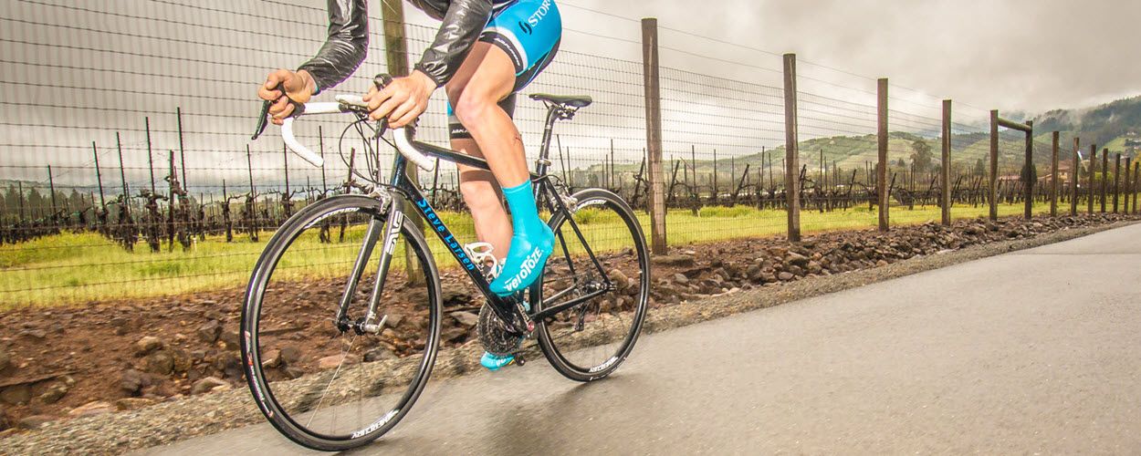 Cyclist wearing bright colored gear riding on a path through nature.