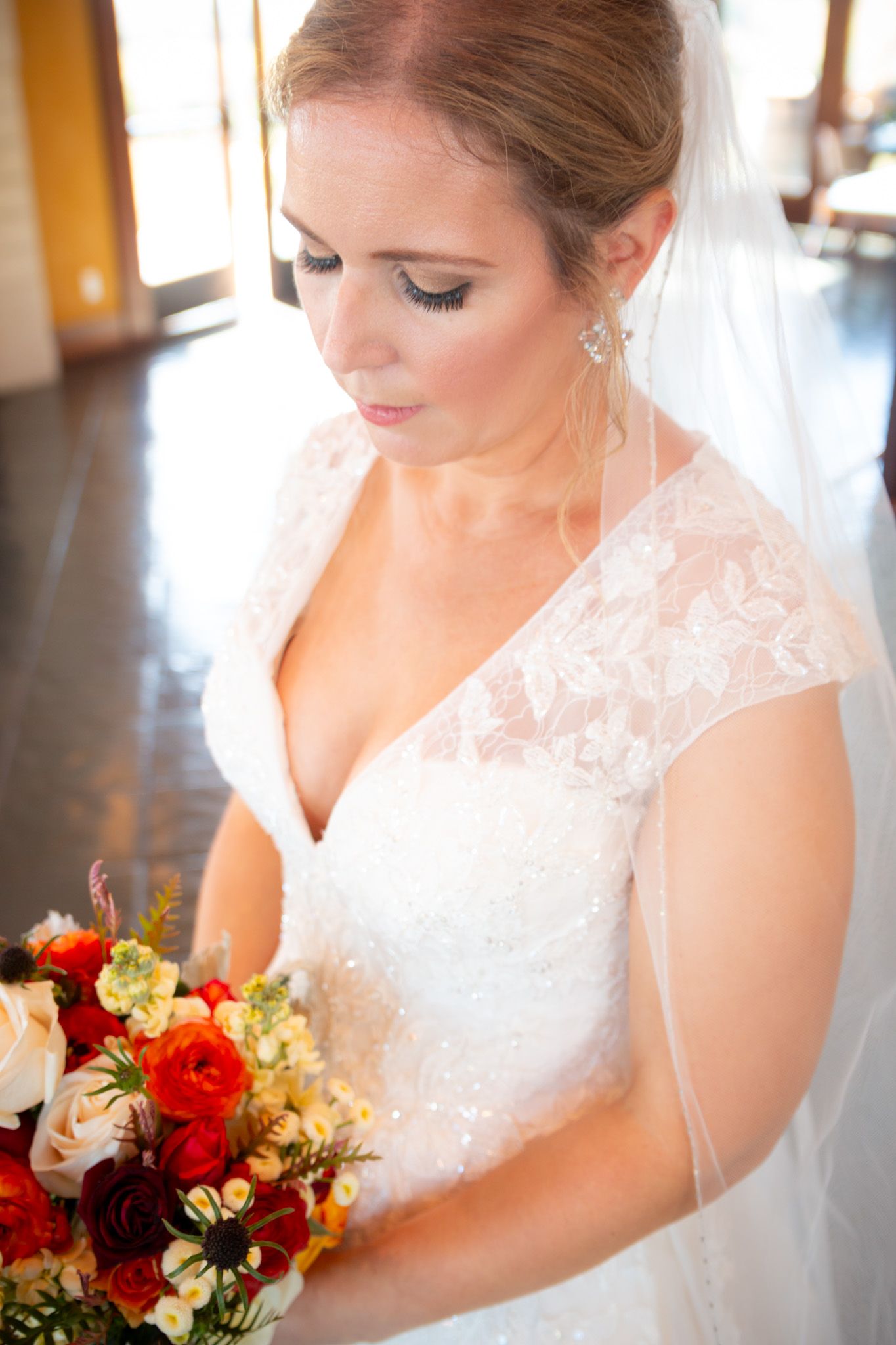 Bridal portrait showing lace dress details and colorful autumn bouquet.