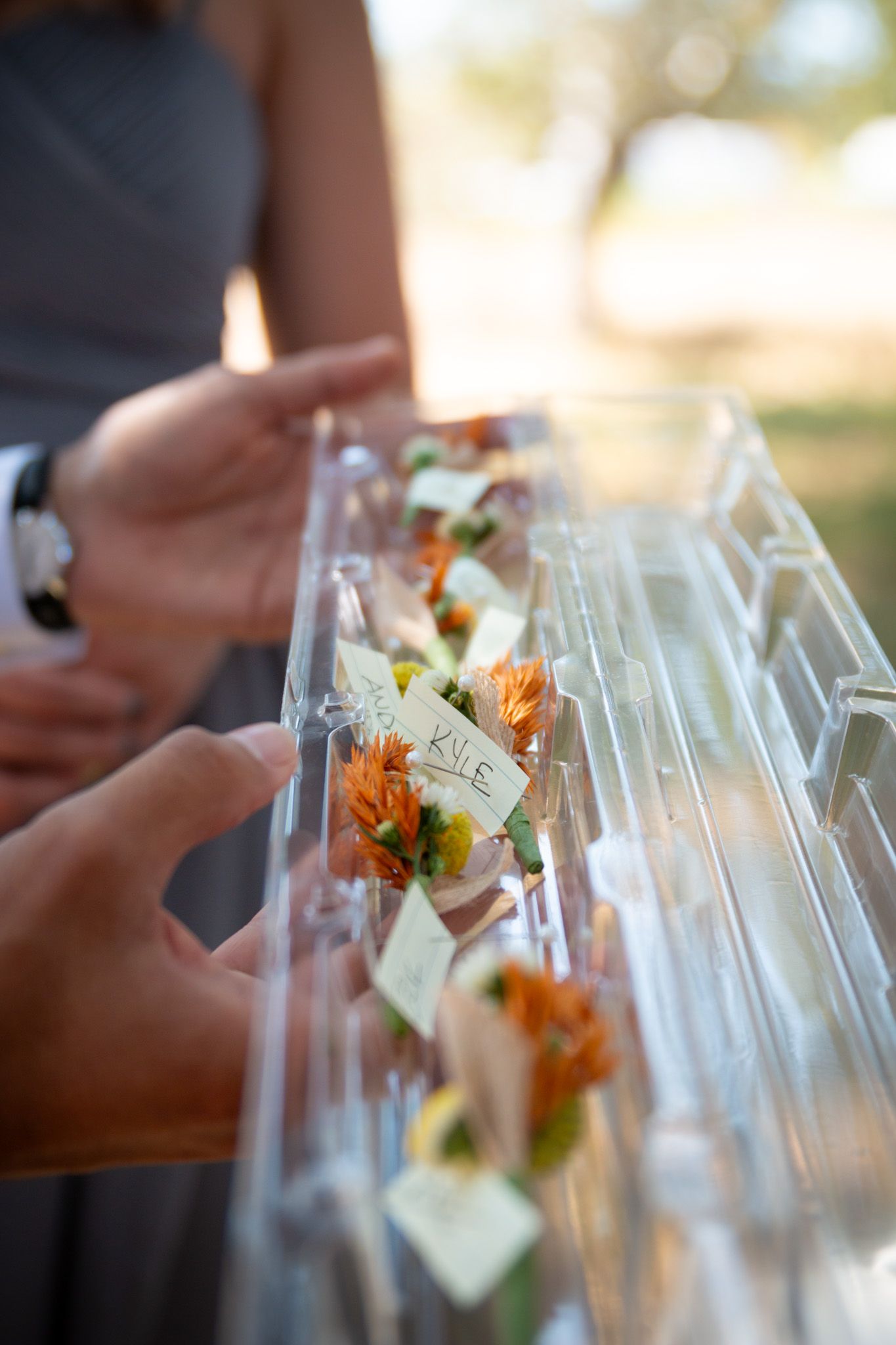 Glass test tubes filled with colorful flower arrangements being set up for wedding reception.