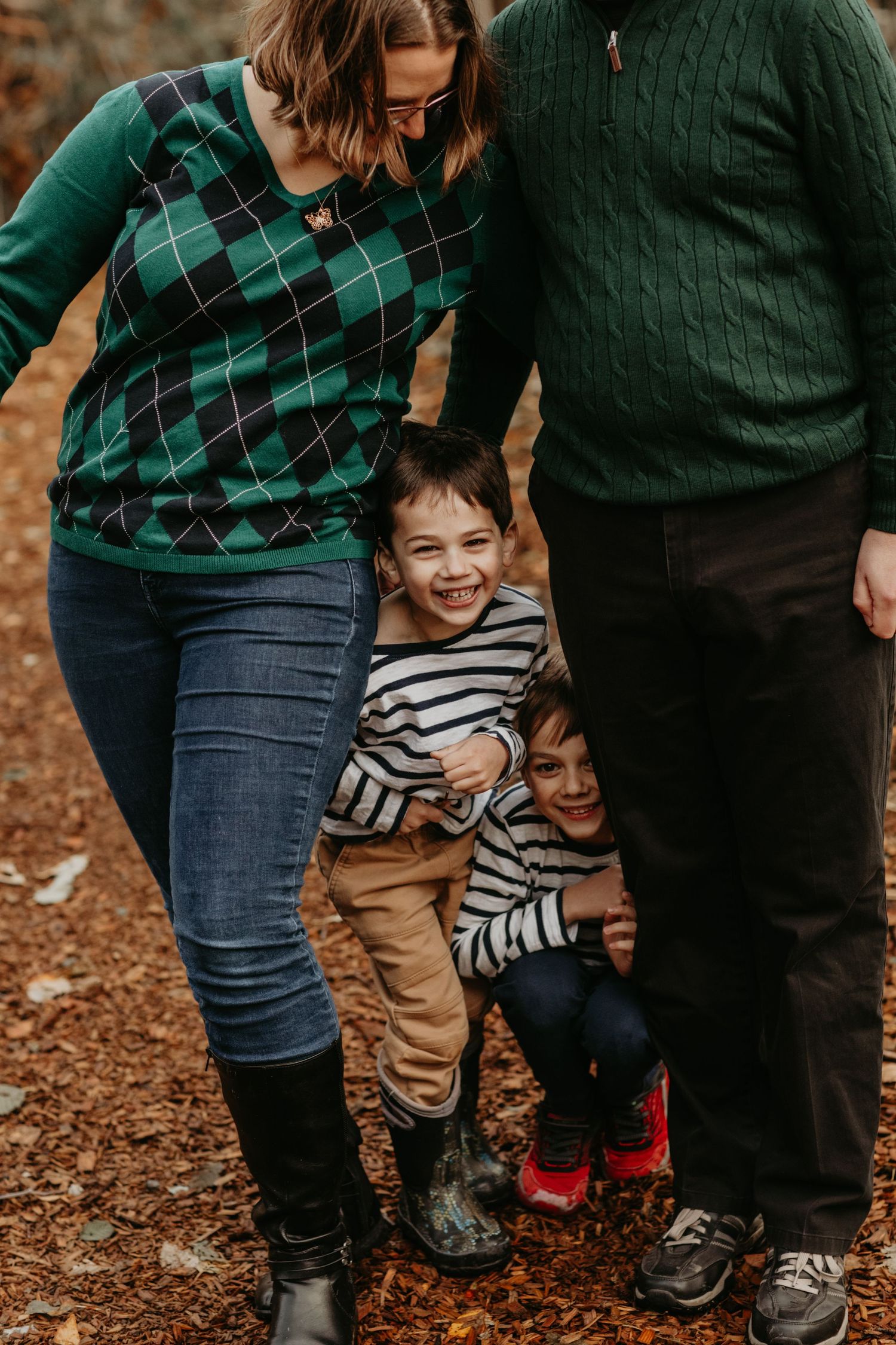 A candid lifestyle photo showing green sweaters and stripes against an autumn woodland backdrop.