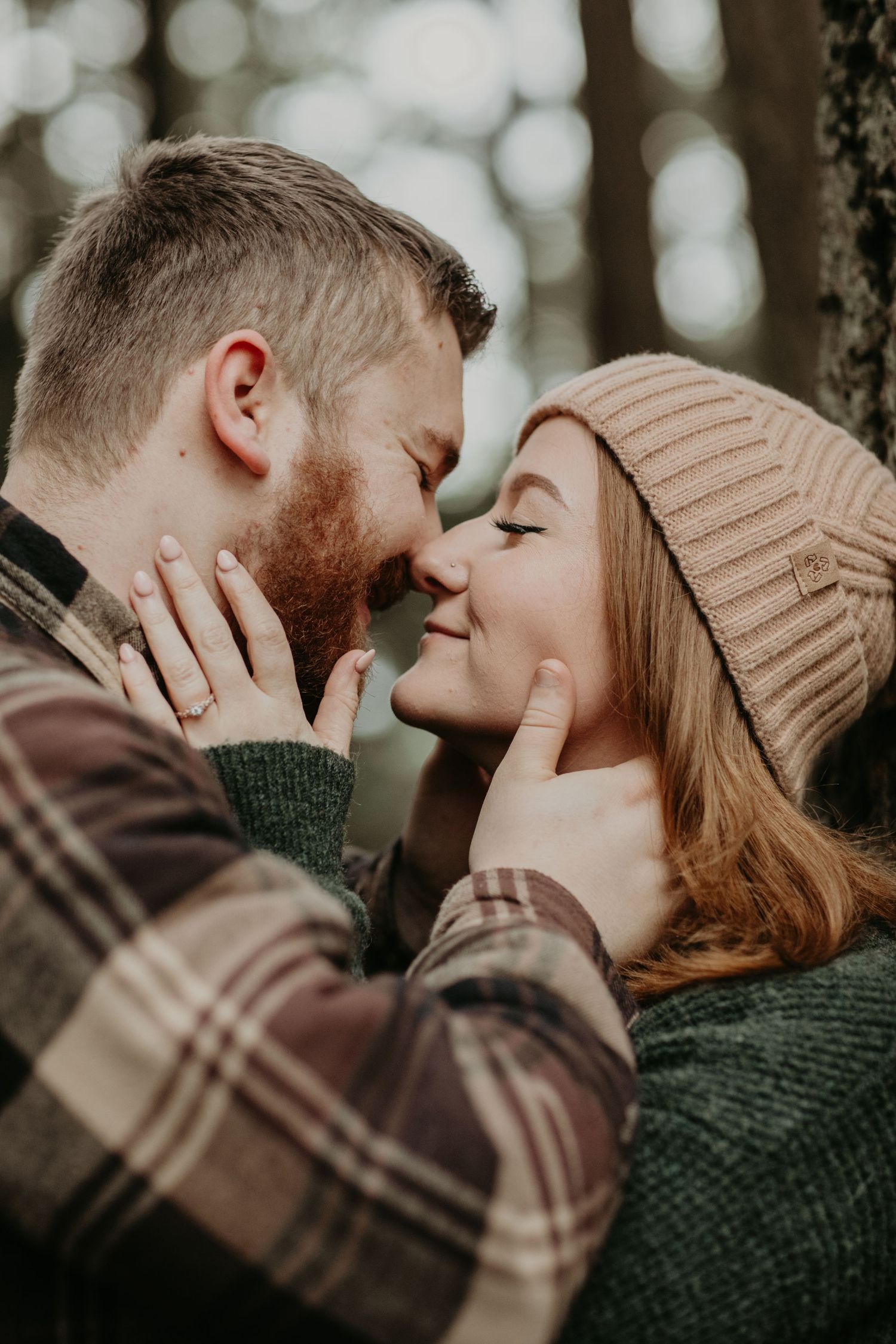 Romantic couple sharing an intimate moment outdoors with soft bokeh background and warm autumn styling.