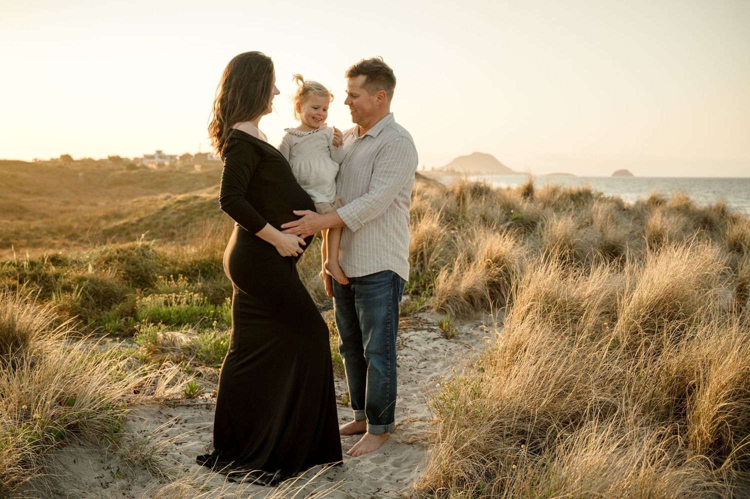 Family portrait at sunset on coastal path with toddler.