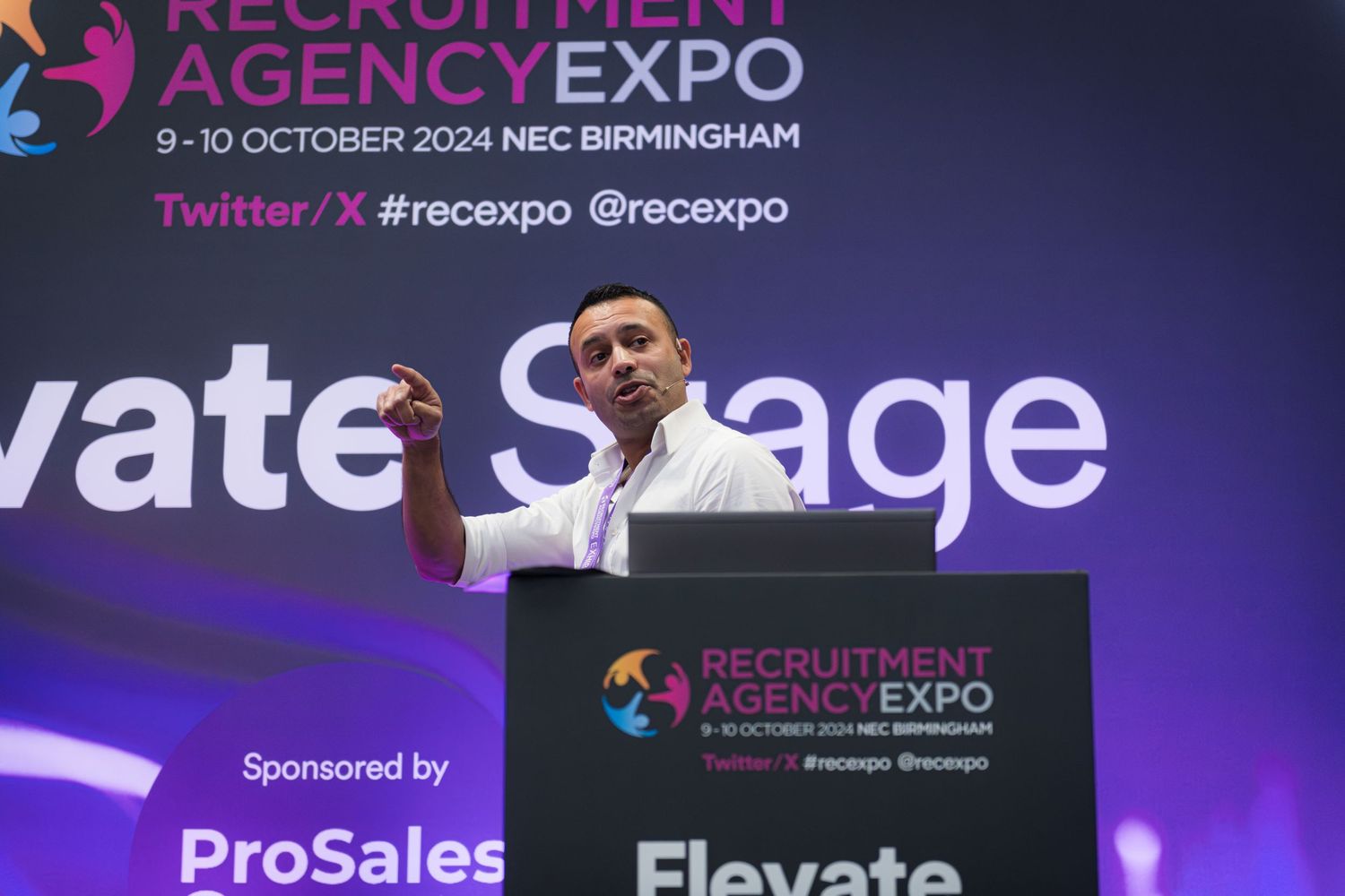 Speaker presenting on stage at the Recruitment Agency Expo in Birmingham.